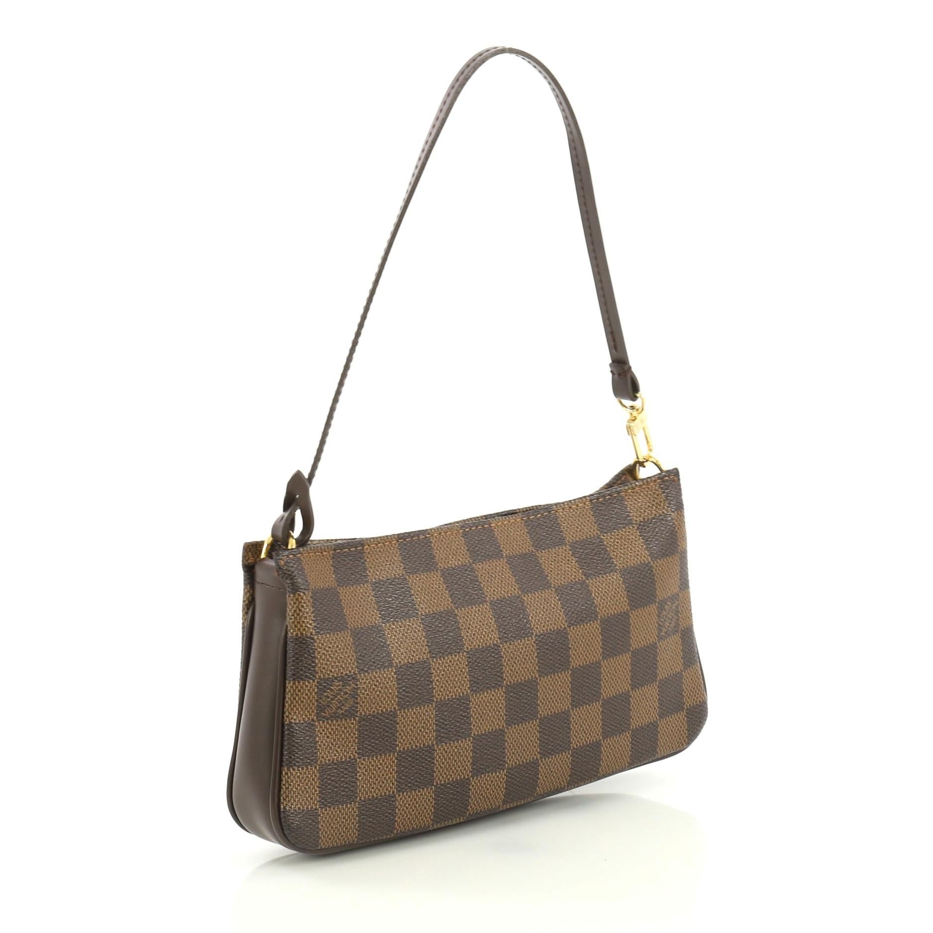 This Louis Vuitton Navona Pochette Accessoires Damier, crafted from damier ebene coated canvas, features a flat leather strap and gold-tone hardware. Its zip closure opens to a red fabric interior. Authenticity code reads: FL0036. 

Condition: