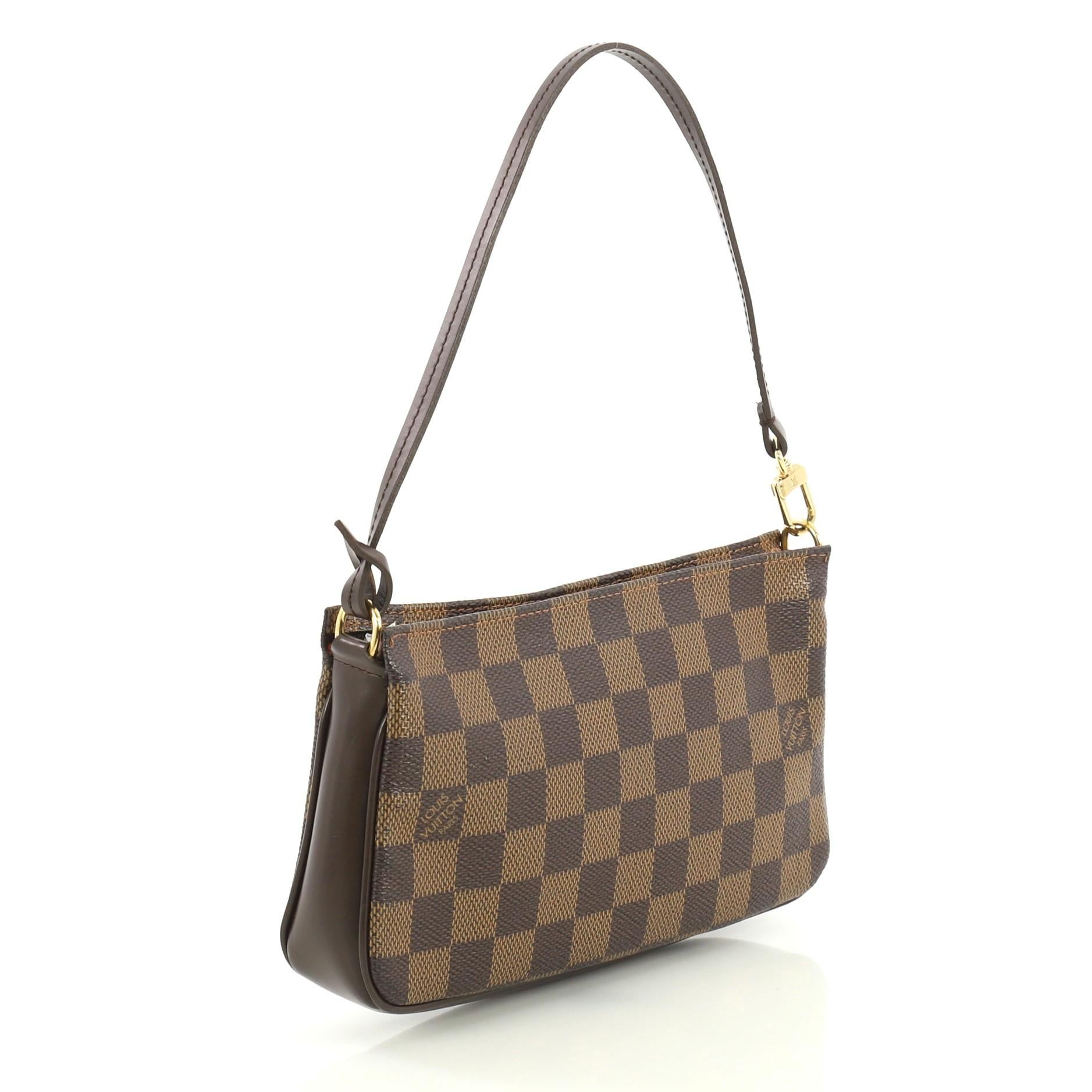 This Louis Vuitton Navona Pochette Accessoires Damier, crafted from damier ebene coated canvas, features a flat leather strap and gold-tone hardware. Its zip closure opens to a red fabric interior. Authenticity code reads: FL0072. 

Condition:
