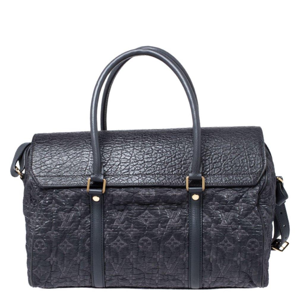 This bag is from Louis Vuitton's Fall/Winter 2010 Runway Collection. It is a limited edition piece made from monogram embossed canvas and detailed with a leather flap. On top, there are two leather handles and on the base, there are four metal