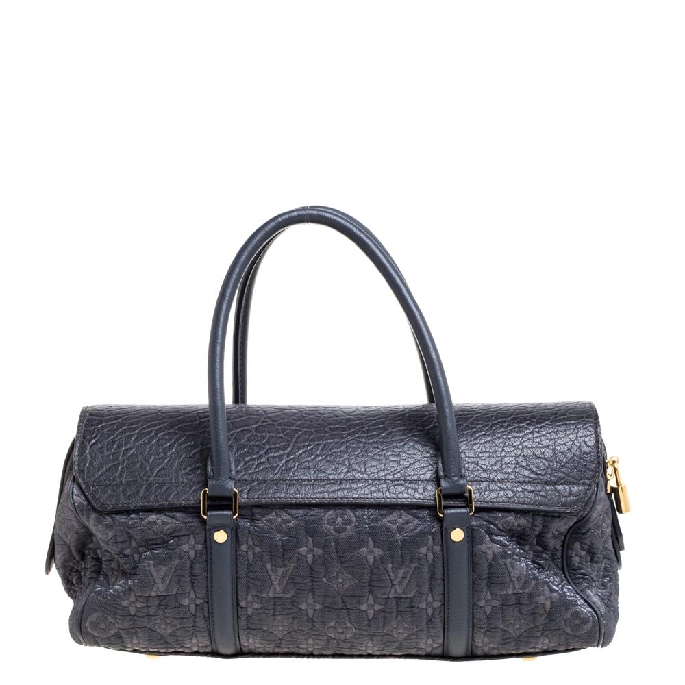 This bag is from Louis Vuitton's Fall/Winter 2010 Runway Collection. It is a limited edition piece made from monogram embossed jacquard fabric and detailed with a leather flap. On top, there are two handles and on the base, there are four metal