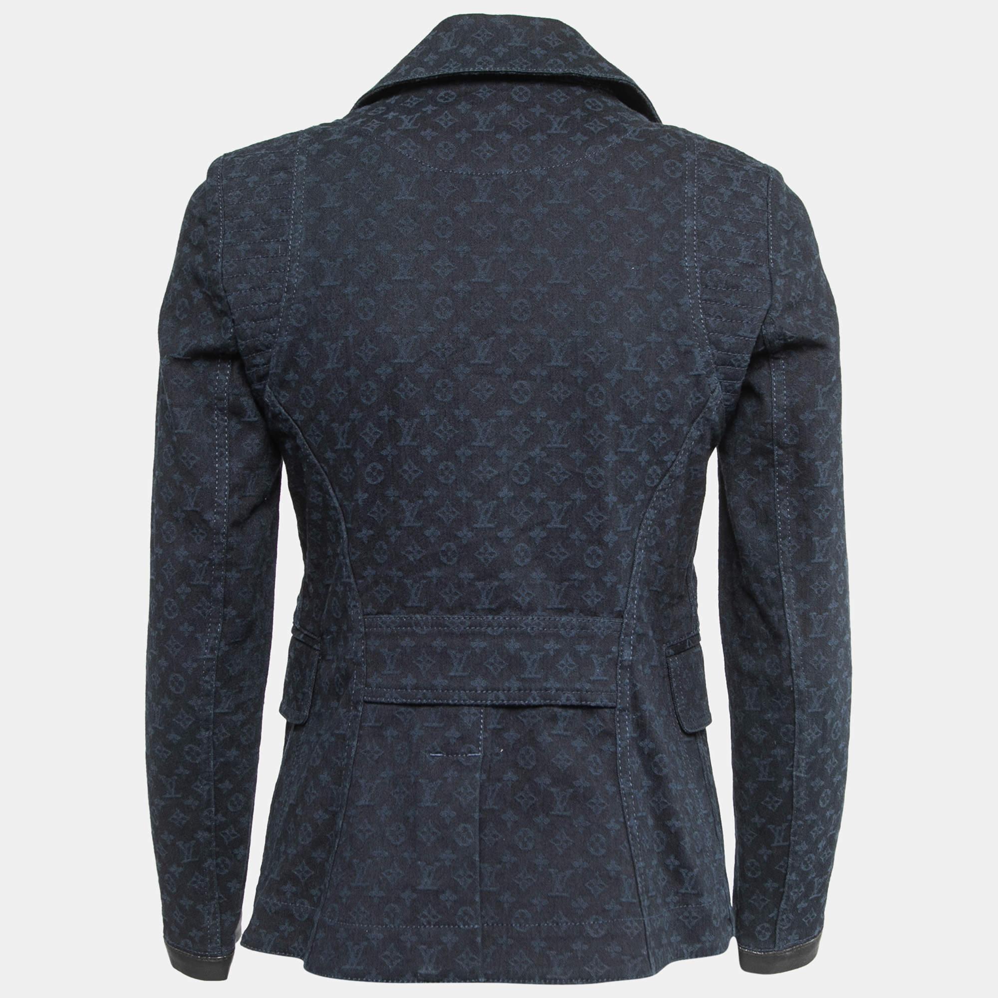 It features a navy blue color with the iconic Louis Vuitton monogram pattern intricately woven into the fabric. The blazer is made from high-quality denim, adding a contemporary touch to the classic design. With its tailored fit and attention to