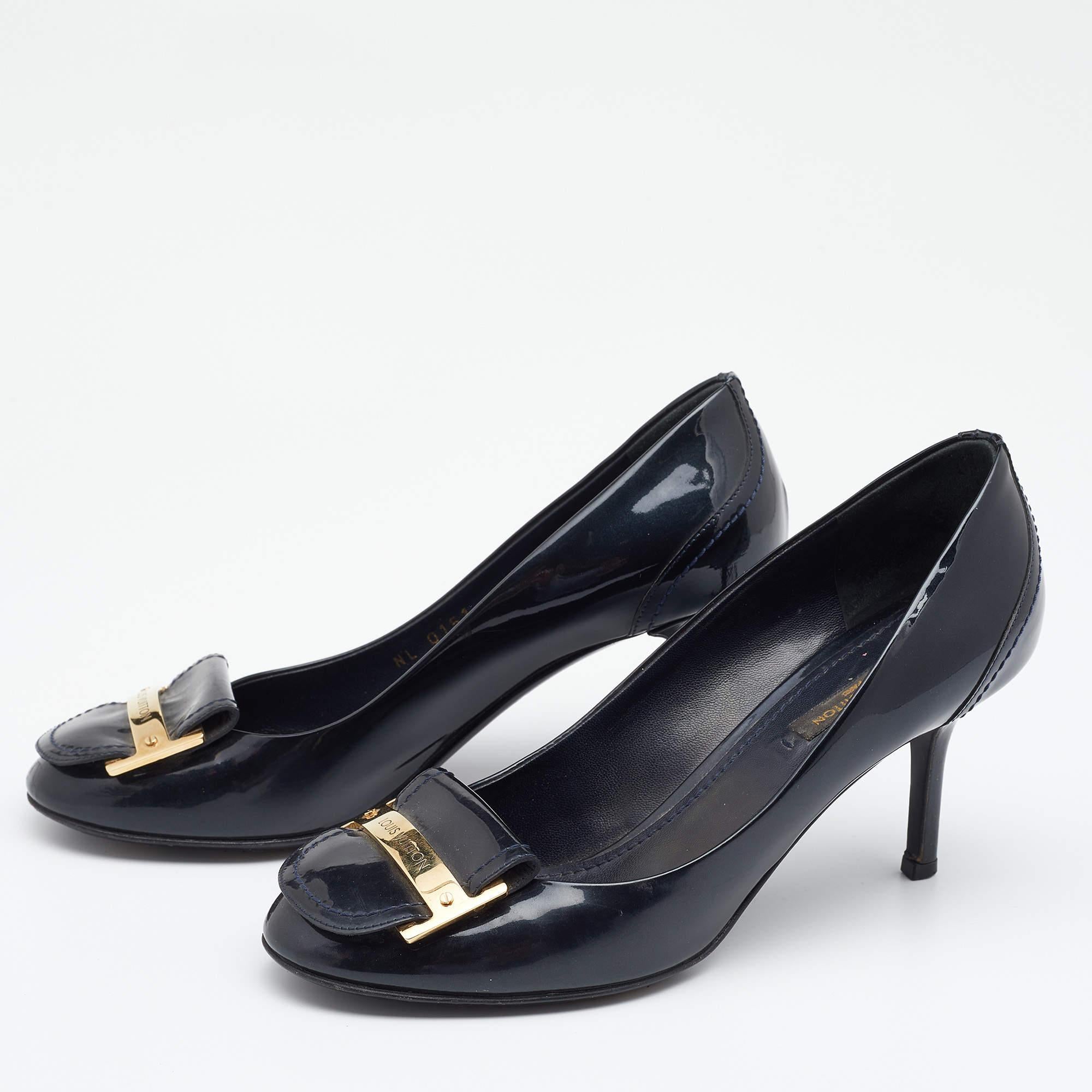 Outline a sophisticated look in these chic pumps from Louis Vuitton. They are designed using navy-blue patent leather on the exterior. These pumps have slender heels, covered-toes, and a slip-on feature. They are adorned with gold-tone hardware.