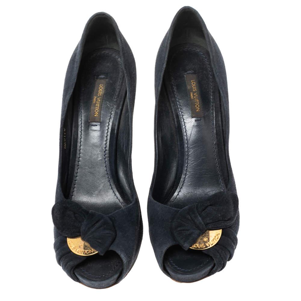 These Louis Vuitton peep-toe pumps are crafted in navy blue suede and are adorned with pretty bow detailing and gold-tone logo-engraved plaques. These beauties sit on 10 cm heels to lend you an elegant height.

Includes: Original Dustbag

