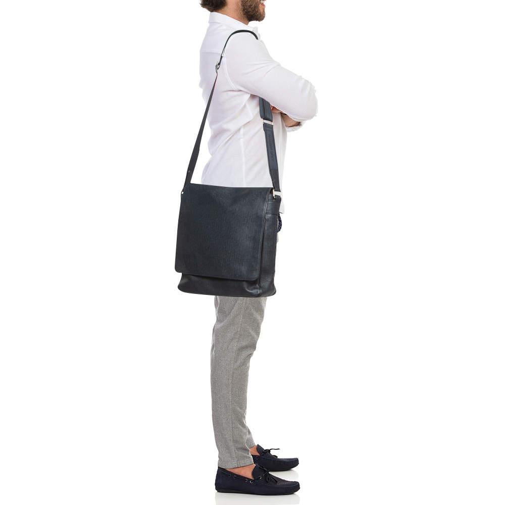 A great alternative to your regular office bag this Roman MM bag from Louis Vuitton exudes a minimal style with hints of class and sophistication. It is crafted in a luxurious navy blue Taiga leather in a flap silhouette. It comes fitted with a flat
