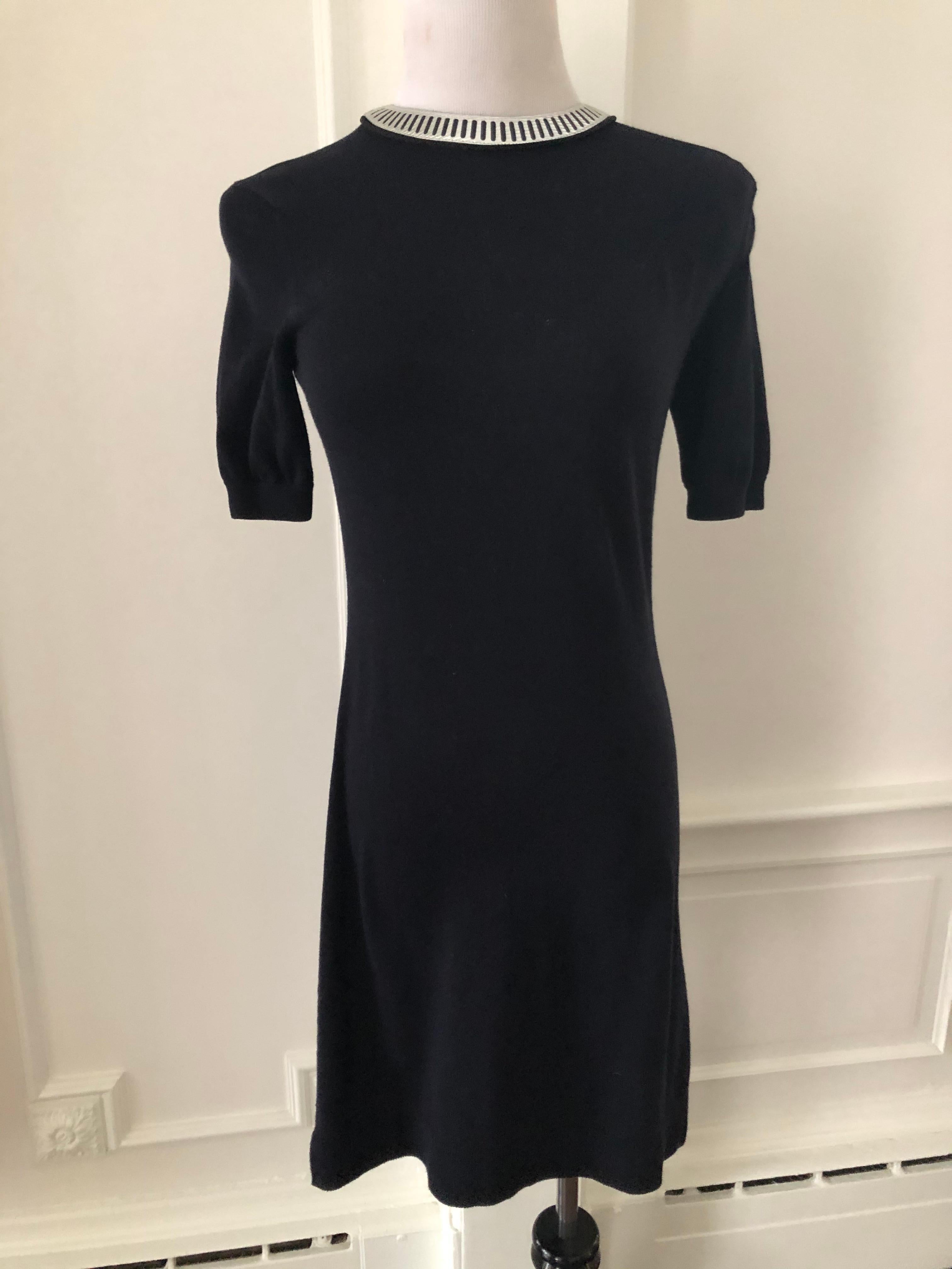 Sort sleeve navy cotton knit dress. Back hook and eye closure.
Silver embellishment at neckline.
Simple and chic. Very good condition.
Measurements
Shoulders       18