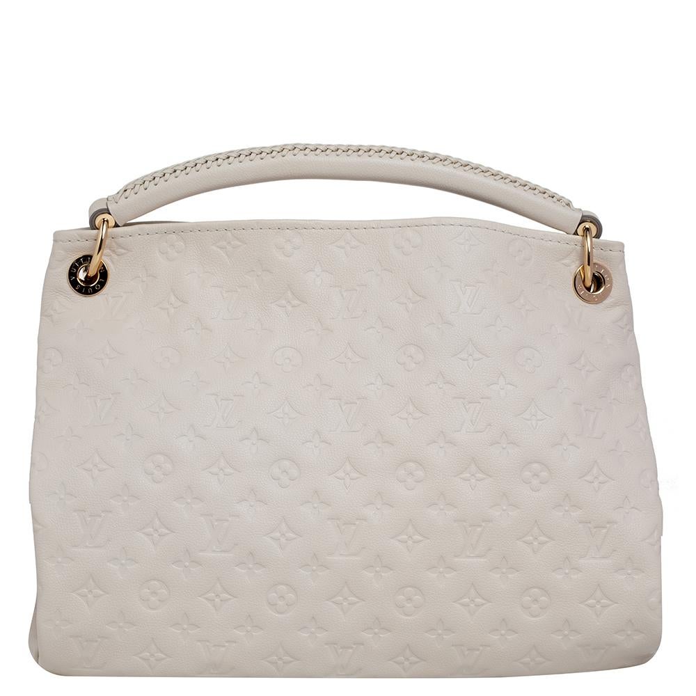 Flaunt this Louis Vuitton Artsy bag like a fashionista! Crafted from their signature Monogram Empreinte leather, this bag features an open top that reveals a canvas-lined interior, spacious enough to carry all your essentials. The bag is completed