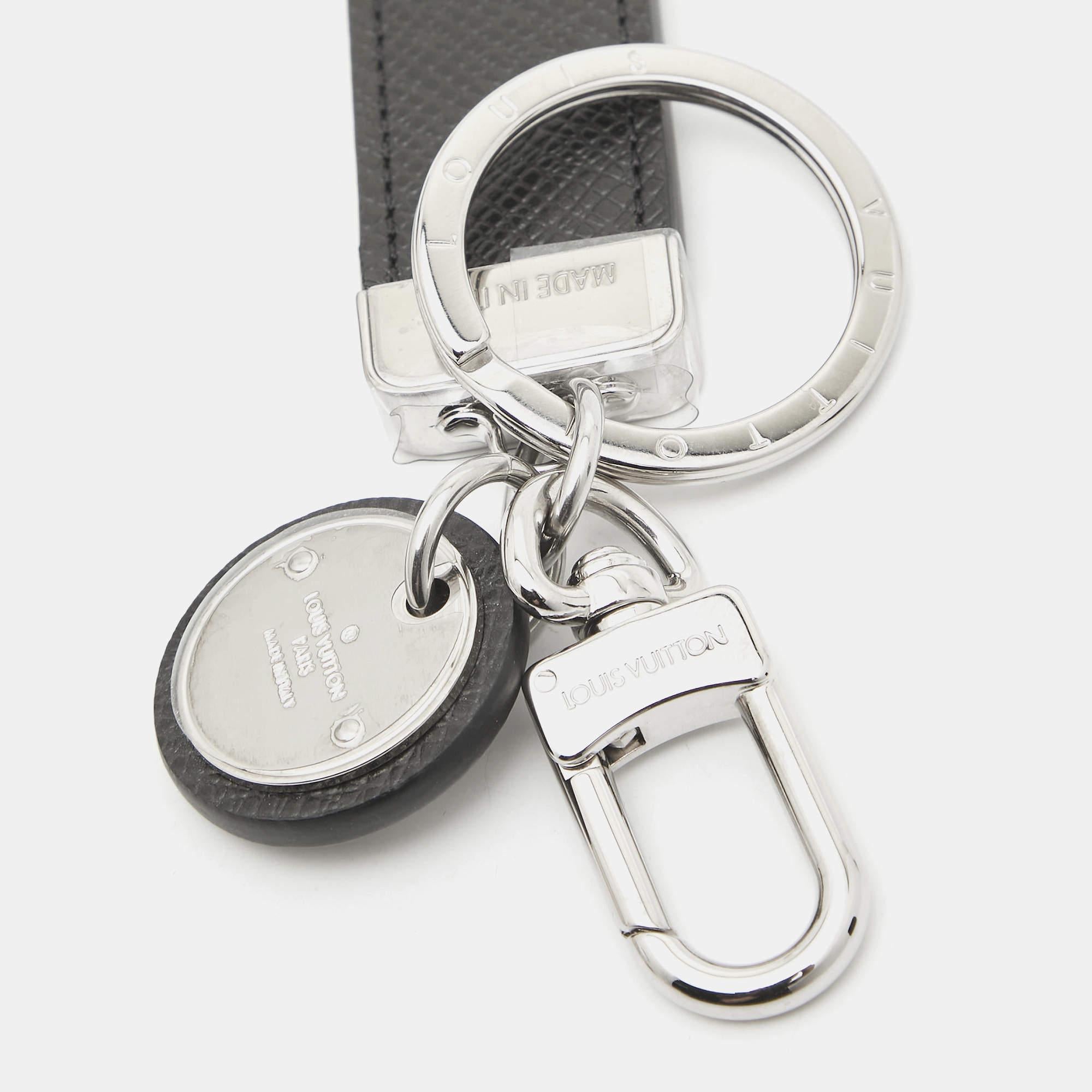 The Louis Vuitton key ring showcases the brandâ€™s iconic Monogram Eclipse canvas  paired with sleek silver tone hardware. This accessory is designed with a functional clasp and key ring  perfect for securing keys or adding a stylish touch to bags.