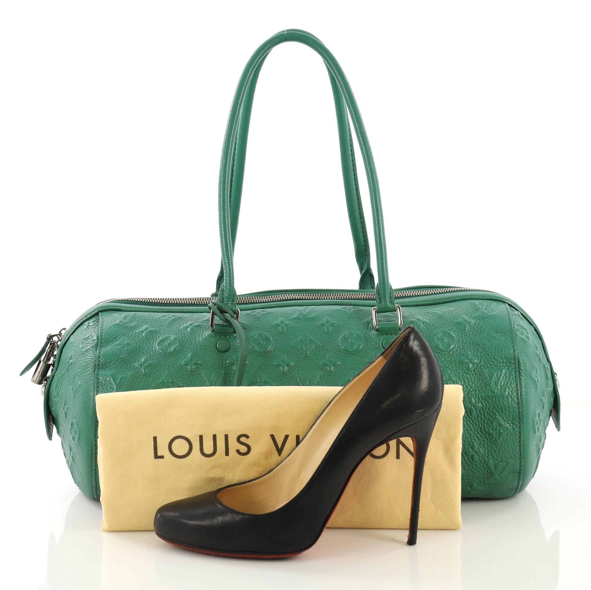 This Louis Vuitton Neo Papillon Handbag Monogram Revelation GM, constructed in green monogram Revelation leather, features tall dual-rolled leather top handles, protective leather base tabs and silver-tone hardware. Its zip closure opens to a