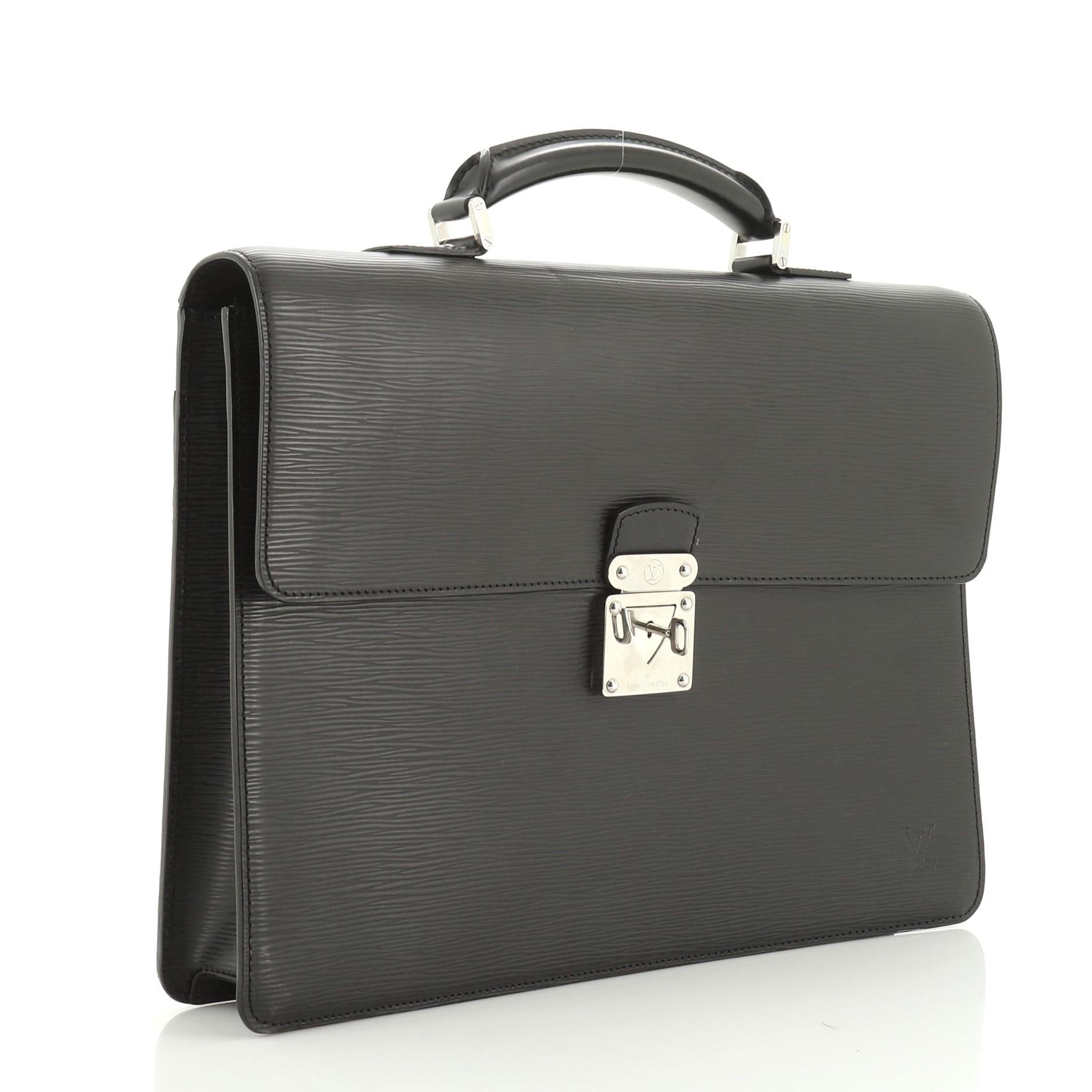 This Louis Vuitton Neo Robusto 1 Briefcase Epi Leather, crafted in black epi leather, features rolled leather top handle with links, gusseted sides, exterior back pocket and silver-tone hardware. Its S-lock closure opens to a black fabric interior