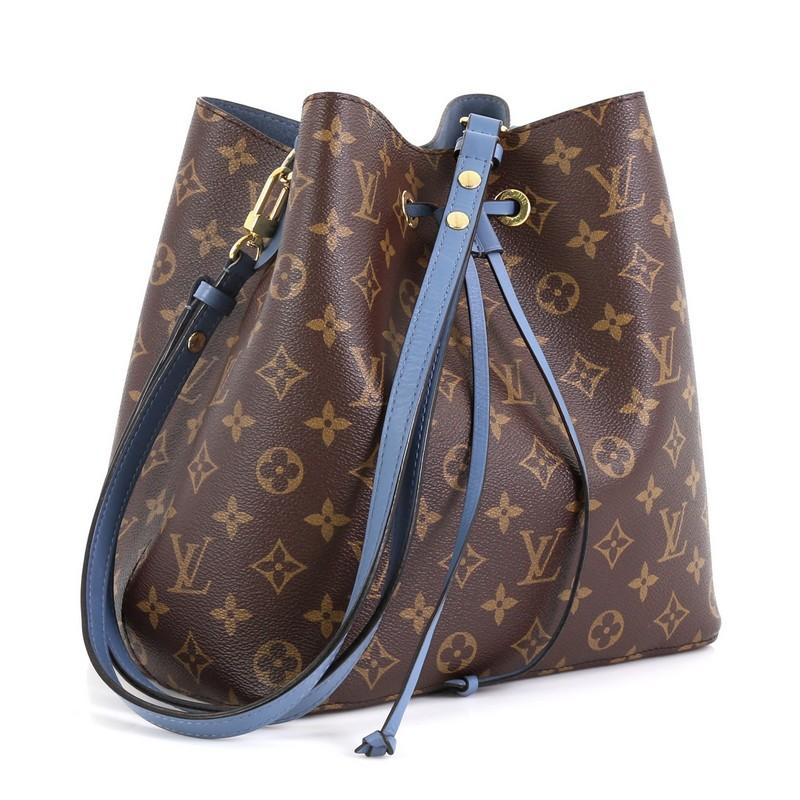 This Louis Vuitton NeoNoe Handbag Monogram Canvas, crafted from brown monogram coated canvas, features a leather shoulder strap and gold-tone hardware. Its drawstring closure opens to a blue microfiber interior divided into two open compartments