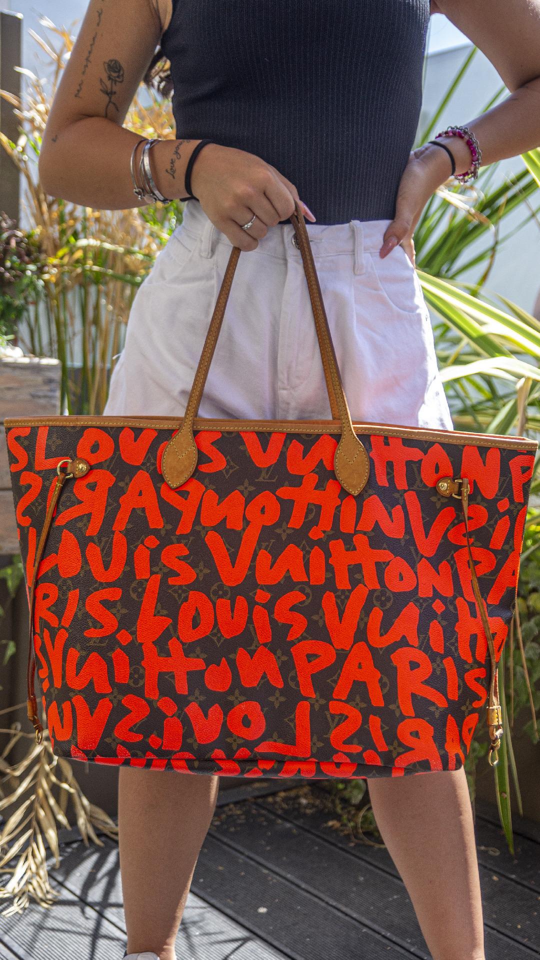 Borsa firmata Louis Vuitton, modello Neverfull, misura GM, in edizione limitata in collaborazione con Stephen Sprouse, realizzata in tela marrone nella classica fantasia monogram con graffiti color arancio fluo, inserti in vacchetta e hardware