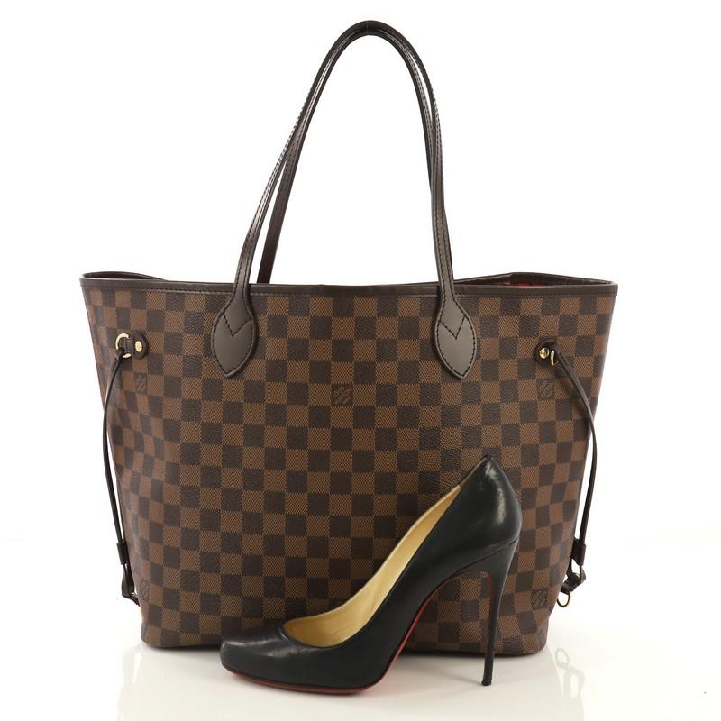 This Louis Vuitton Neverfull NM Tote Damier MM, crafted in damier ebene coated canvas, features dual slim leather handles, side laces and gold-tone hardware. Its wide open top showcases a red striped fabric interior with side zip pocket.