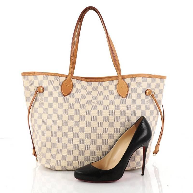 This authentic Louis Vuitton Neverfull Tote Damier MM is a popular and practical oversized tote beloved by many. Constructed with Louis Vuitton's signature damier azur coated canvas, this tote features dual slim vachetta leather handles, side laces