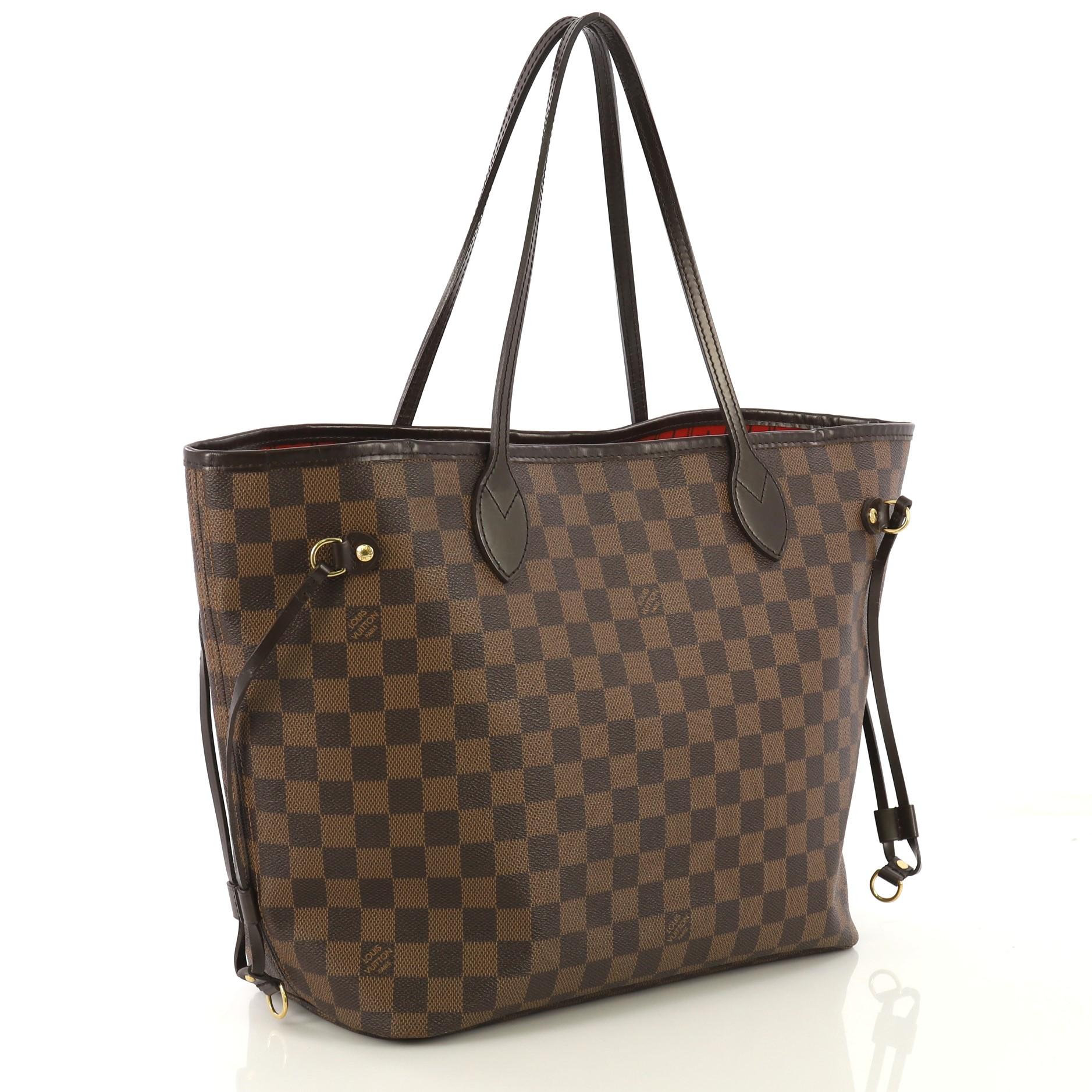 This Louis Vuitton Neverfull Tote Damier MM, crafted in damier ebene coated canvas, features dual slim handles, side laces, and aged gold-tone hardware. Its wide open top showcases a red fabric interior with side zip pocket. Authenticity code reads: