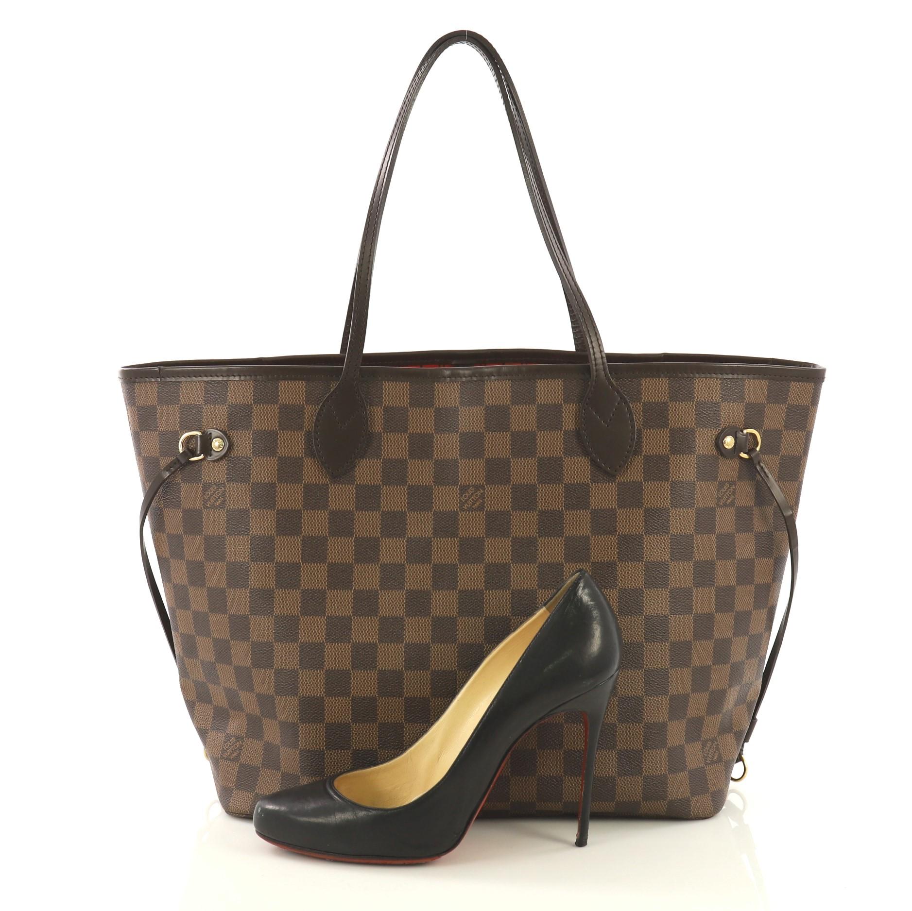This Louis Vuitton Neverfull Tote Damier MM, crafted in damier ebene coated canvas, features dual slim handles, side laces, and gold-tone hardware. Its wide open top showcases a red fabric interior with a side zip pocket. Authenticity code reads: