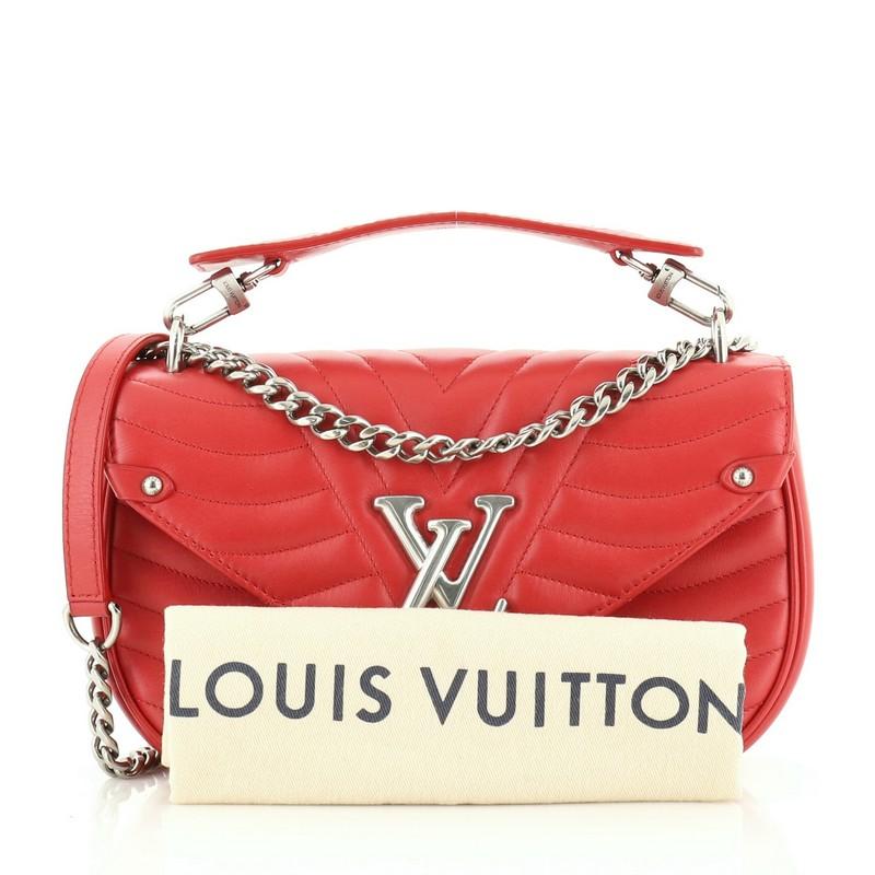 This Louis Vuitton New Wave Chain Bag Quilted Leather MM, crafted from red quilted leather, features a sliding chain-link shoulder strap with leather pad, detachable handle signed “Louis Vuitton,” and aged silver-tone hardware. It opens to a red