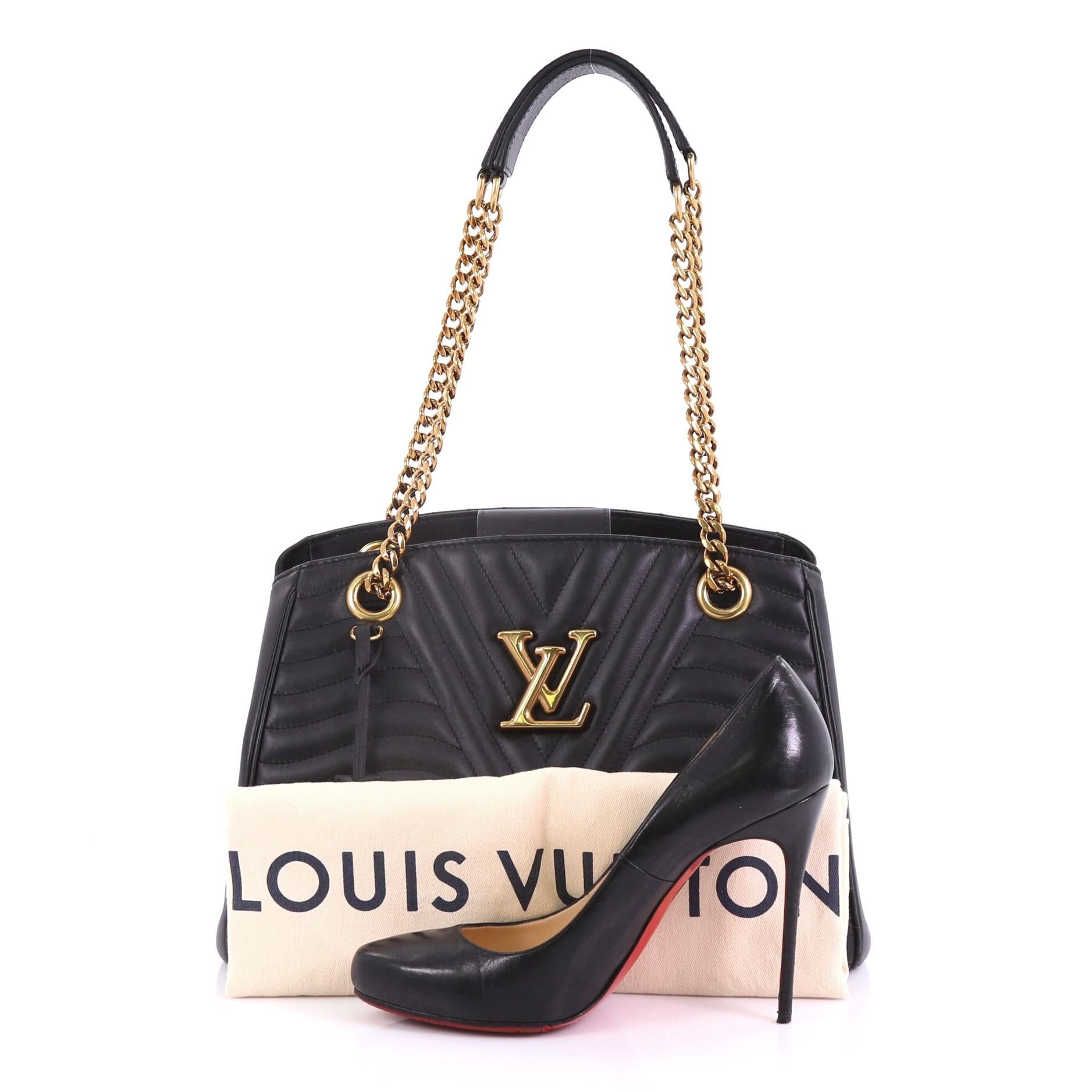 This Louis Vuitton New Wave Chain Tote Quilted Leather, crafted from black quilted leather, features chain-link strap with leather pads signed “Louis Vuitton” and gold-tone hardware. Its magnetic closure opens to a black microfiber interior divided