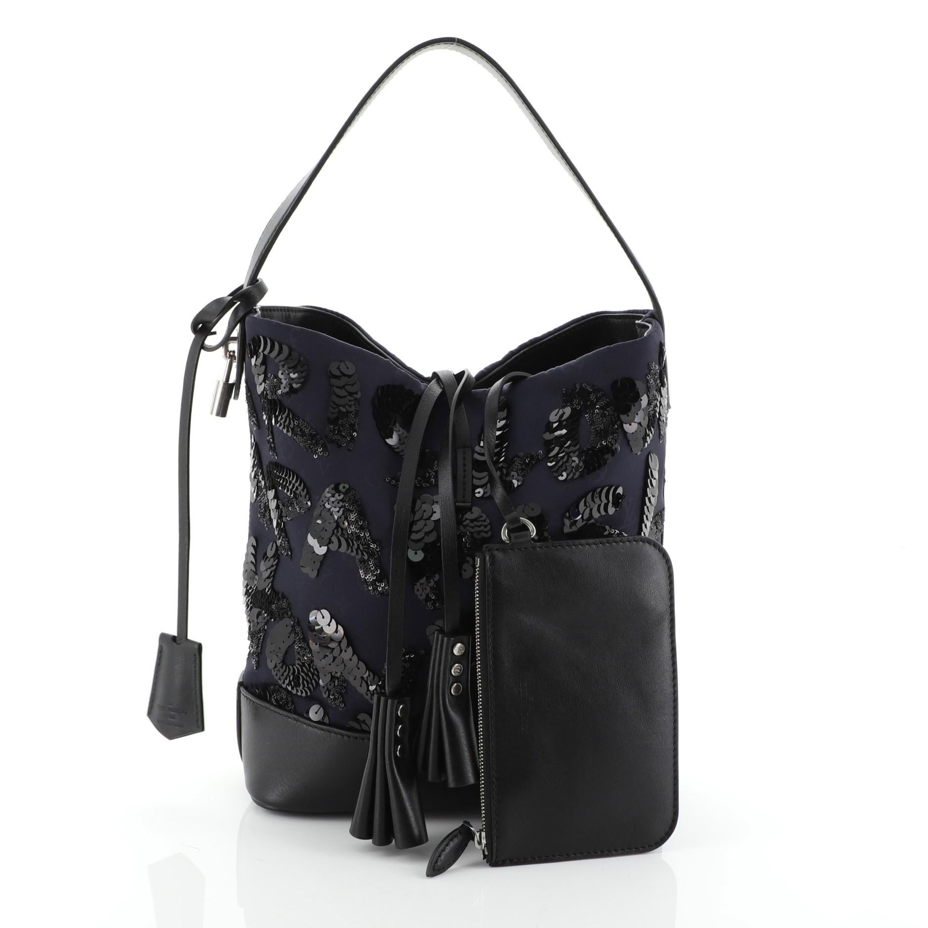 This Louis Vuitton NN14 Spotlight Bucket Bag Sequin Graffiti Monogram Nylon GM, crafted in blue monogram nylon with intricate black sequin monogram lettering, features black calfskin leather base, single looped handle, hand-crafted tassel closure,
