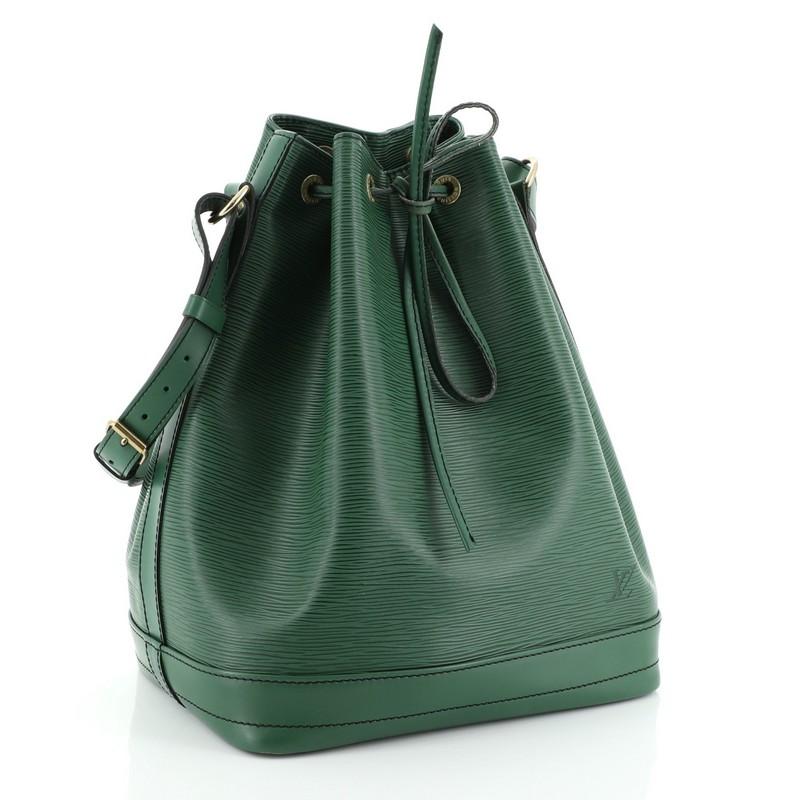 This Louis Vuitton Noe Handbag Epi Leather Large, crafted in green epi leather, features an adjustable shoulder strap, leather drawstring threaded through metal eyelets, and gold-tone hardware. Its drawstring closure opens to a black microfiber