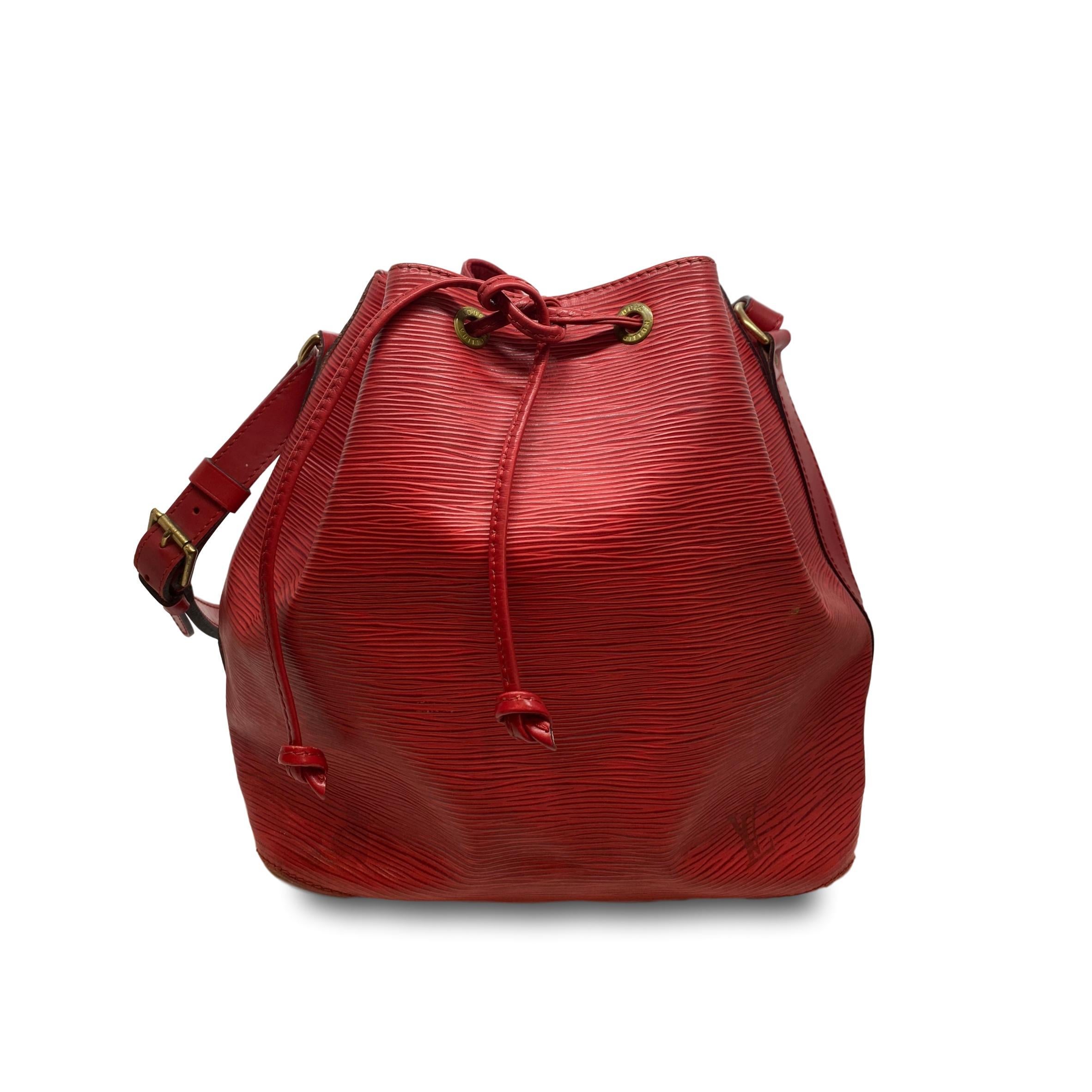 Vintage Louis Vuitton “Noe” PM Bucket Bag in Red EPI Leather, circa 1995. Made in France, the Noe was originally designed by Louis Vuitton’s grandson in 1932 as a bag to carry champagne, specifically four bottles upright and one inverted in the