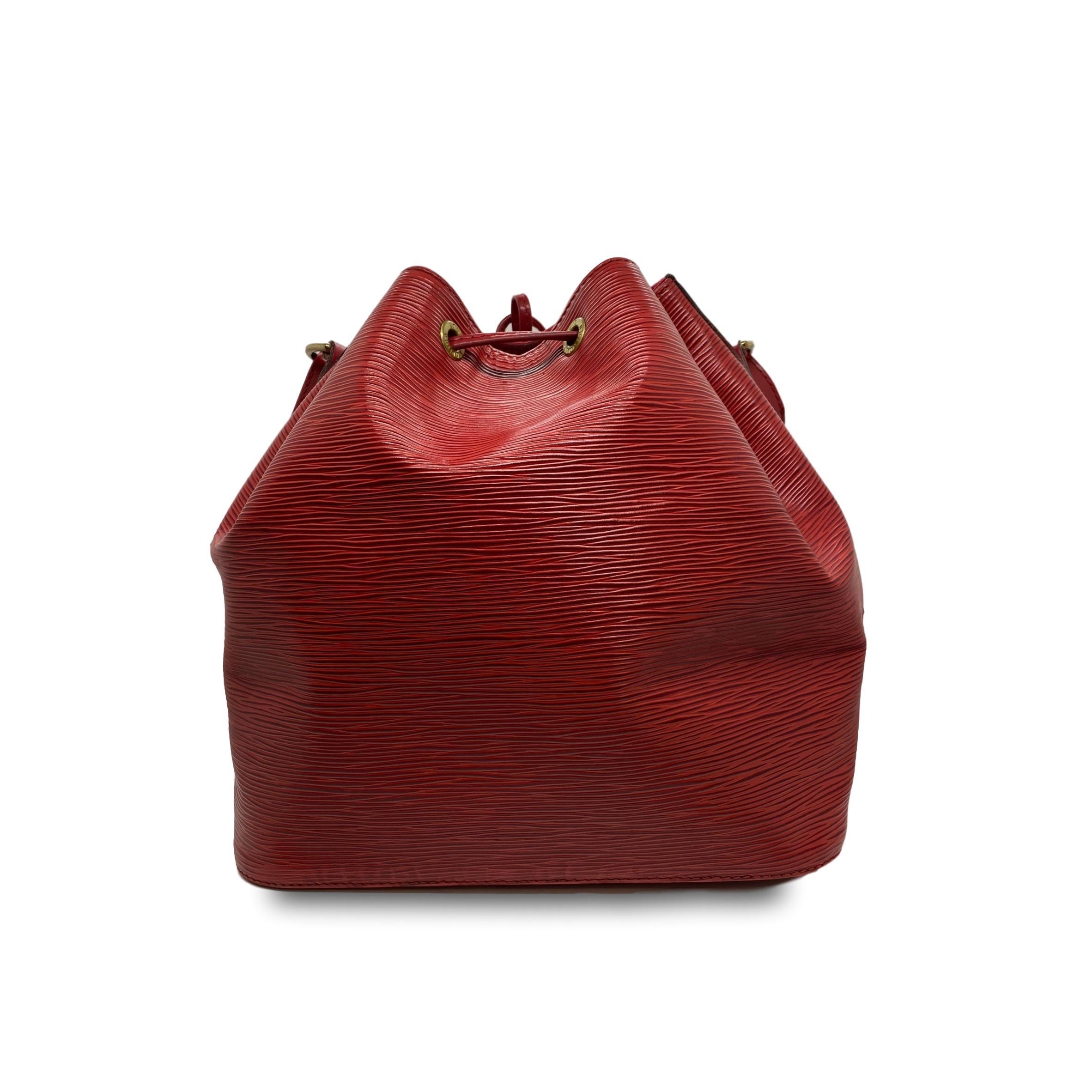 Vintage Louis Vuitton “Noe” Carmine Red EPI Leather Bucket Bag, circa June 1995. Made in France, the Noe was originally designed by Louis Vuitton’s grandson in 1932 as a bag to carry champagne, specifically four bottles upright and one inverted in