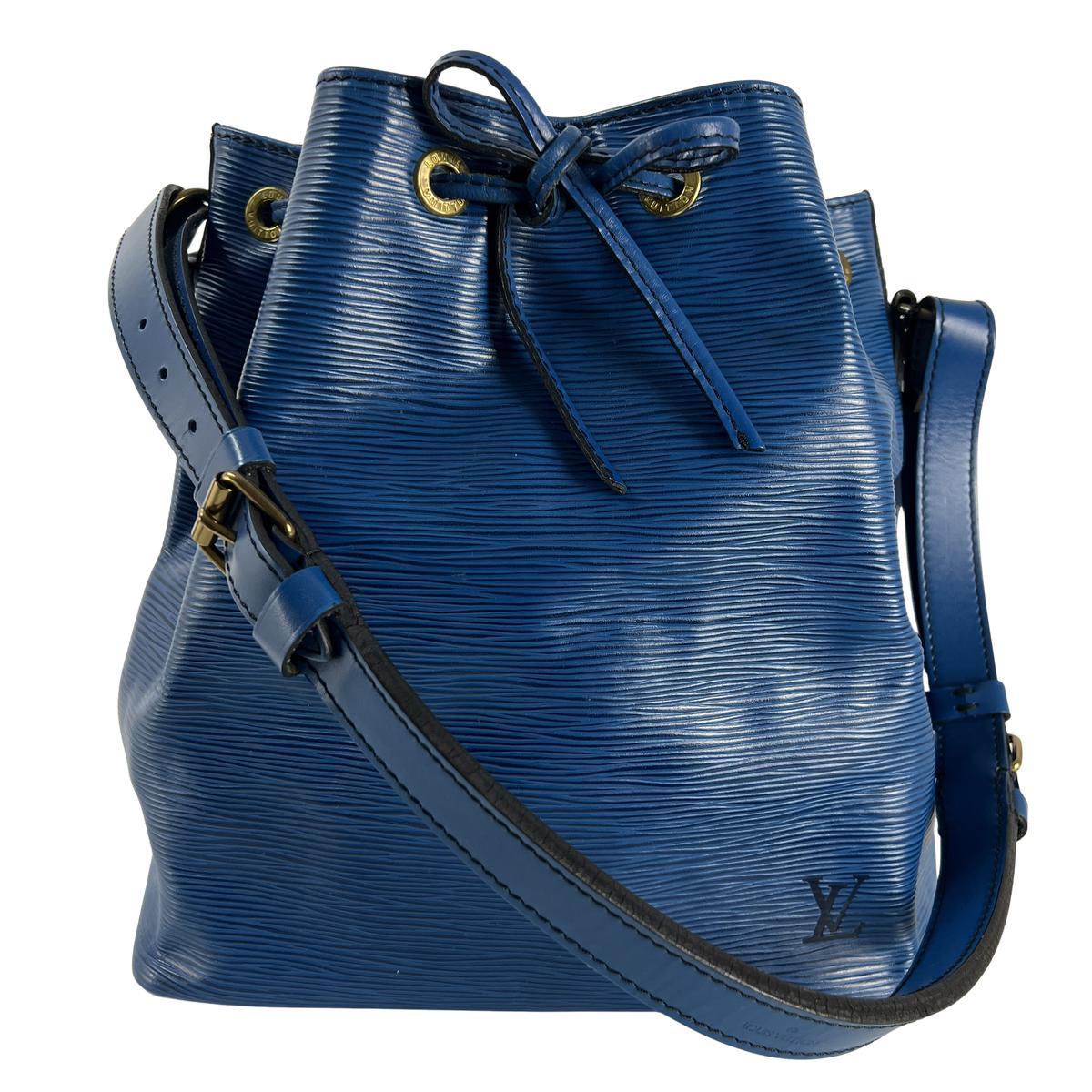 PM Noé in pelle Epi blu con finiture dorate. Chiusura con coulisse; scomparto principale. Codice data A2 0980 (1990), Francia. Condizioni: eccellenti. Dimensioni: 26 × 27 × 20 cm.