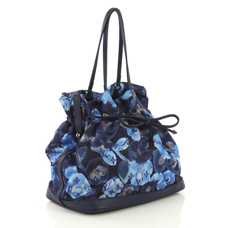 This Louis Vuitton Noefull Handbag Ikat Nylon MM, crafted in blue floral nylon, features dual slim leather handles, leather trim, and gold-tone hardware. Its drawstring closure opens to a blue nylon interior with side zip and slip pockets.