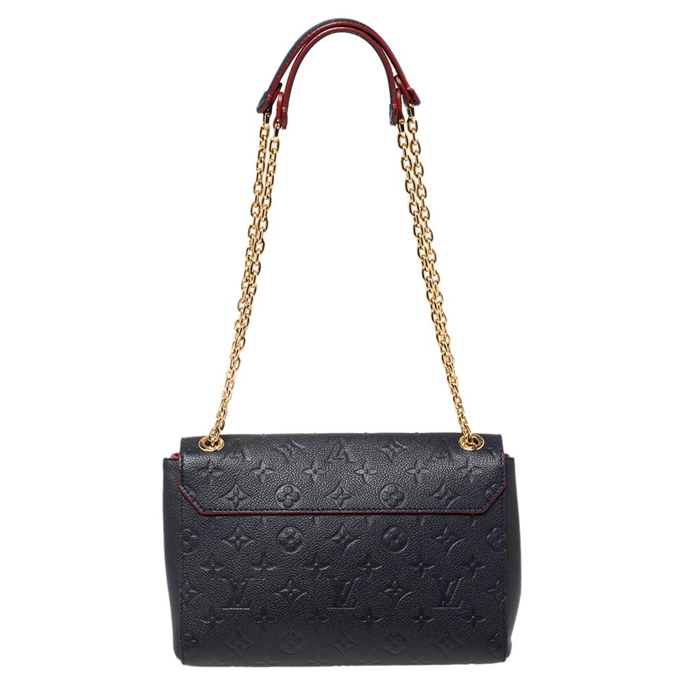 Louis Vuitton's handbags are popular in the fashion world owing to their high style and functionality. This noir Monogram Vavin bag is durable, trendy. Crafted from Empreinte leather, the bag can be paraded around using its top handles. It is