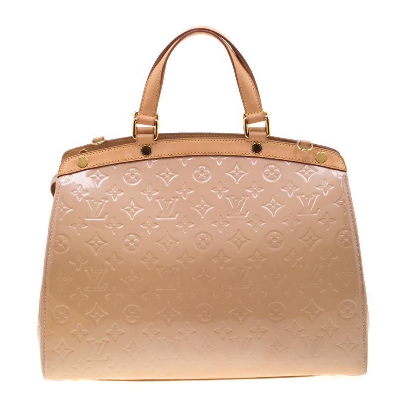 The feminine shape of Louis Vuitton's Brea is inspired by the doctor's bag. Crafted from monogram Vernis patent leather, the bag has a perfect finish. The fabric interior is spacious and it is secured by a zipper. The bag features double handles, a