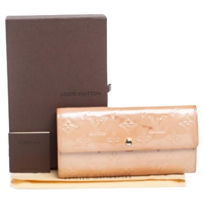 L'un des portefeuilles les plus célèbres de Louis Vuitton est le Sarah. Celui-ci est réalisé en cuir Monogram Vernis et le bouton du rabat s'ouvre sur un intérieur doté de plusieurs fentes pour cartes et d'une poche zippée. D'une taille parfaite, ce