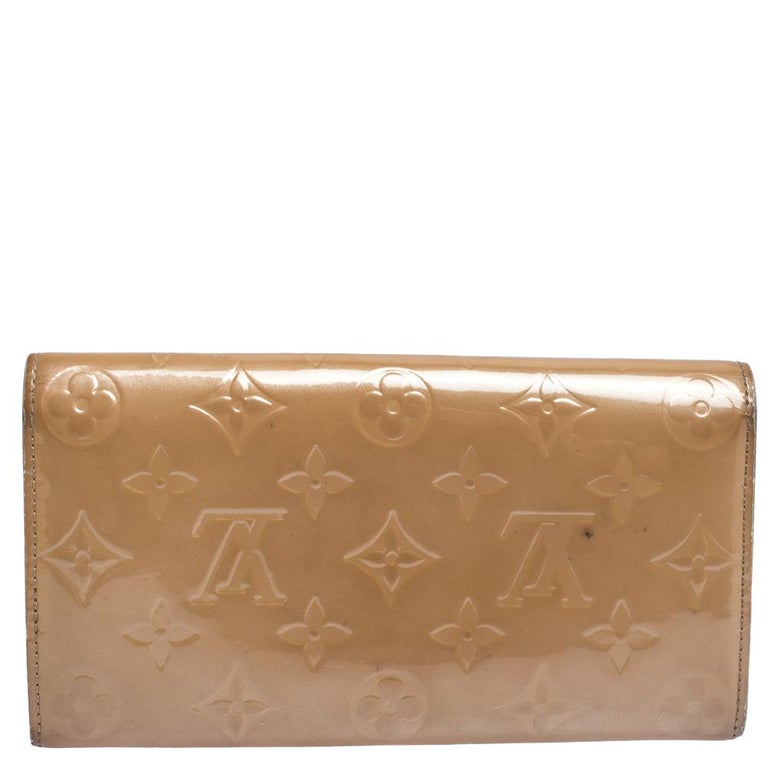 One of the most famous wallets by Louis Vuitton is Sarah. This one here comes made from monogram Vernis leather and the button on the flap opens to an interior with multiple card slots and a zip pocket. Perfect in size, this wallet can easily fit