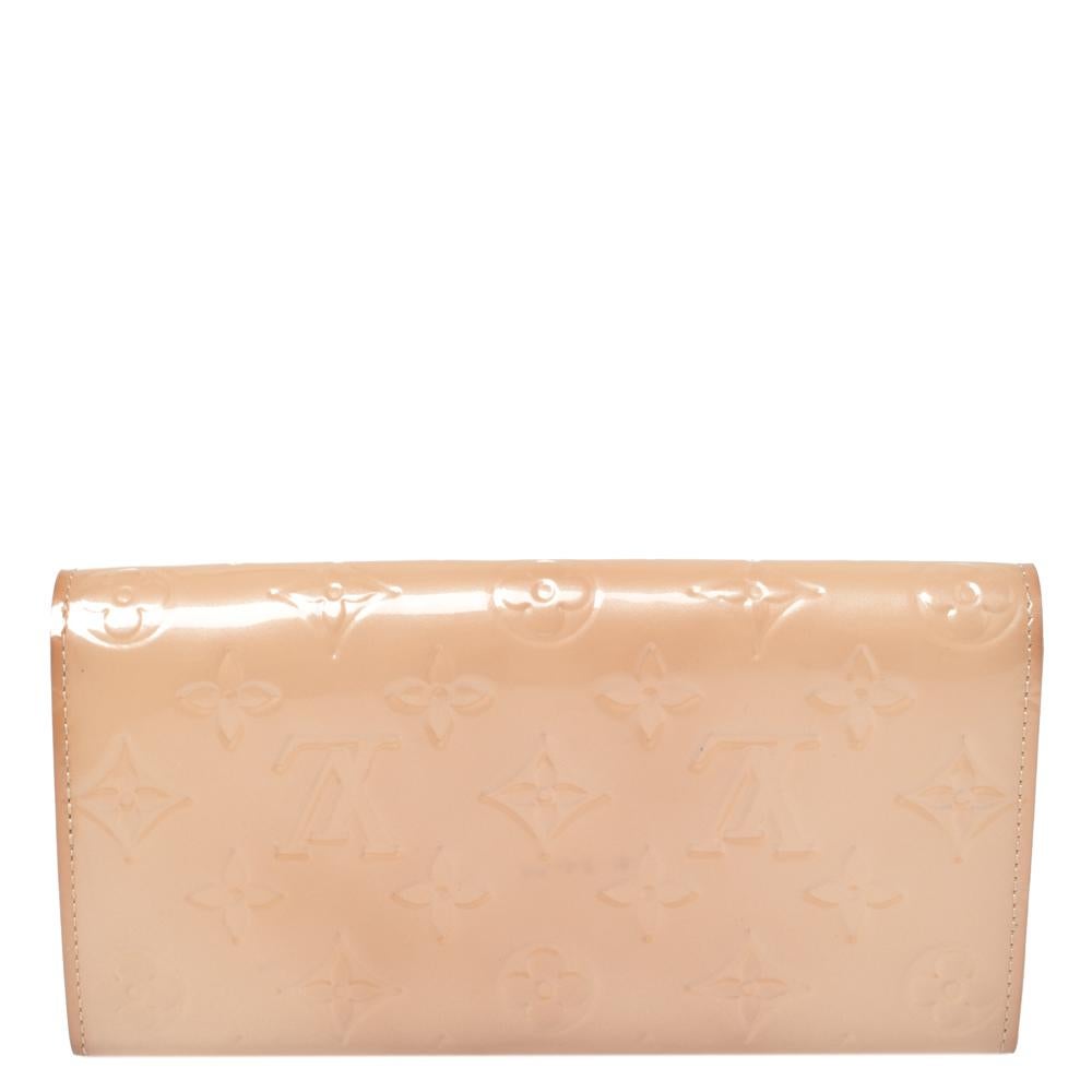 One of the most famous wallets by Louis Vuitton is the Sarah. This one here comes made from Monogram Vernis and the button on the flap opens to an interior with multiple card slots and a zip pocket. Perfect in size, this wallet can easily fit inside