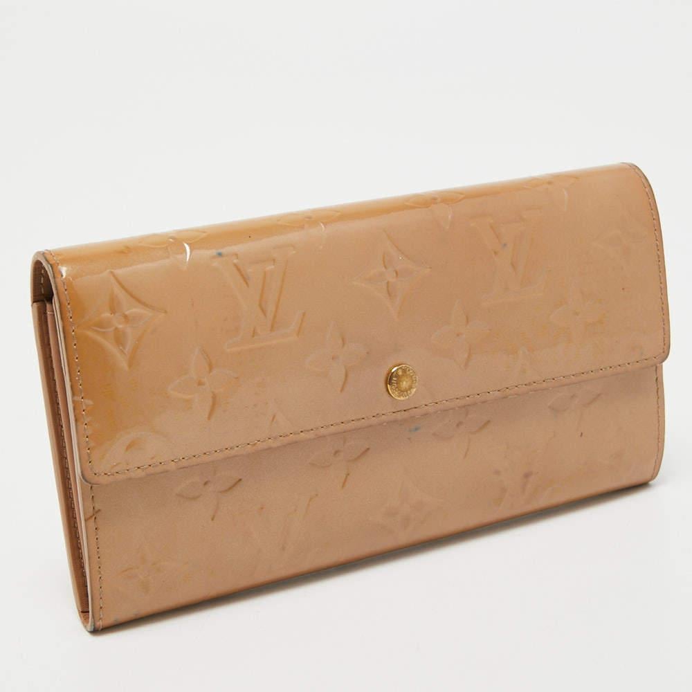 Crafted from the signature Noisette Monogram canvas, this Louis Vuitton Sarah wallet is a valuable accessory. Its compartmentalized interior is perfect to store your monetary essentials, and the gold-tone accents add to the charm of the wallet.

