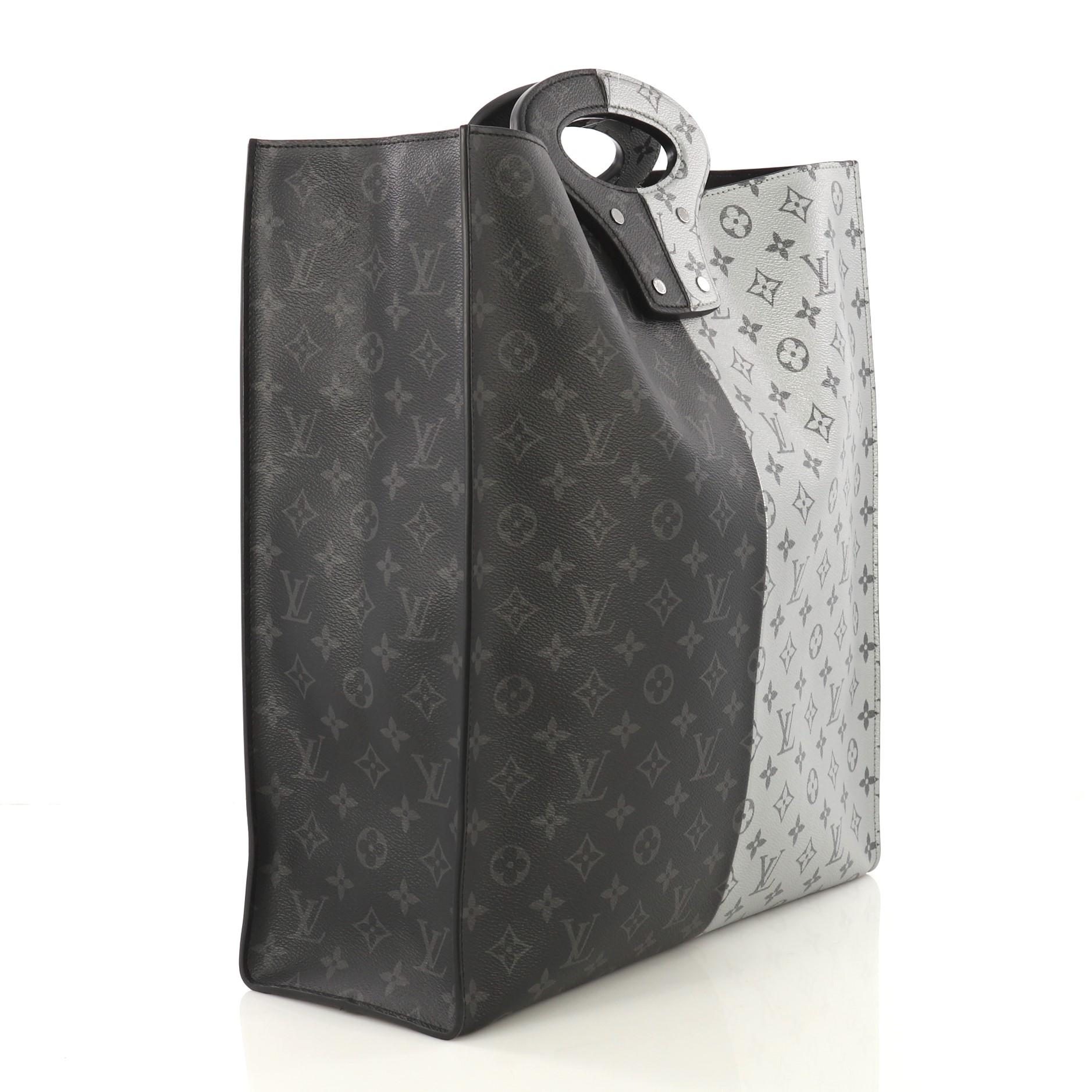 This Louis Vuitton North South Tote Monogram Eclipse Split Canvas, crafted from silver and black monogram eclipse split coated canvas, features dual top handles and gunmetal-tone hardware. It opens to a black microfiber interior with zip pocket.