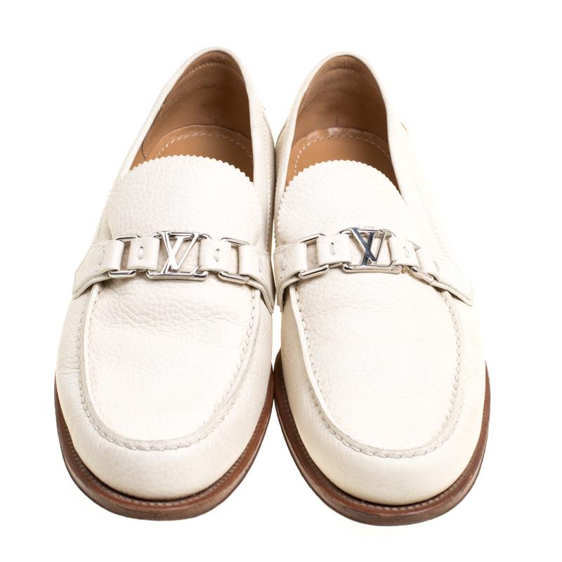 Crafted with beauty from leather, this pair of off-white loafers by Louis Vuitton is a blend of luxury and comfort. They feature the signature LV on the uppers in silver tone, leather-lined insoles and another LV accent on the heels. The loafers