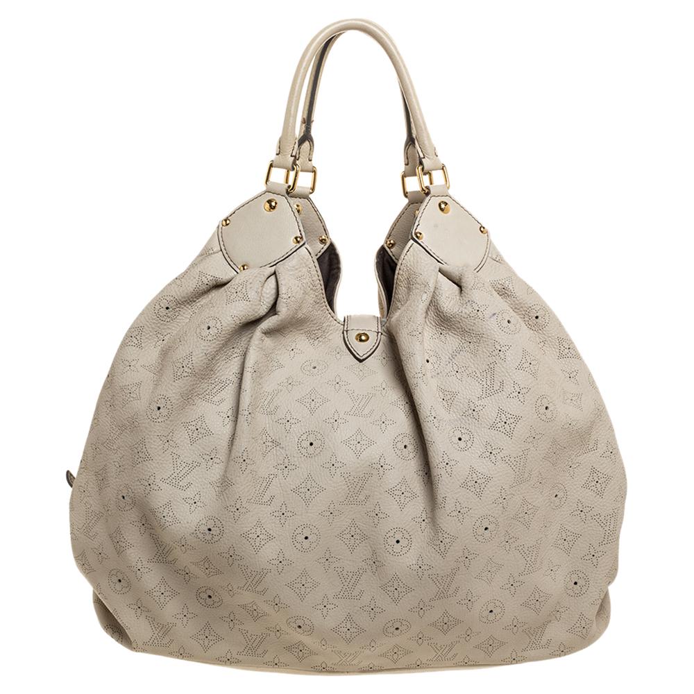 This Louis Vuitton bag is designed exquisitely. Its subtle off-white body is roomy and perfect for everyday use. Crafted from intricate perforated LV monogram leather, it features top handles, a flap tab with a push-lock closure that leads to an