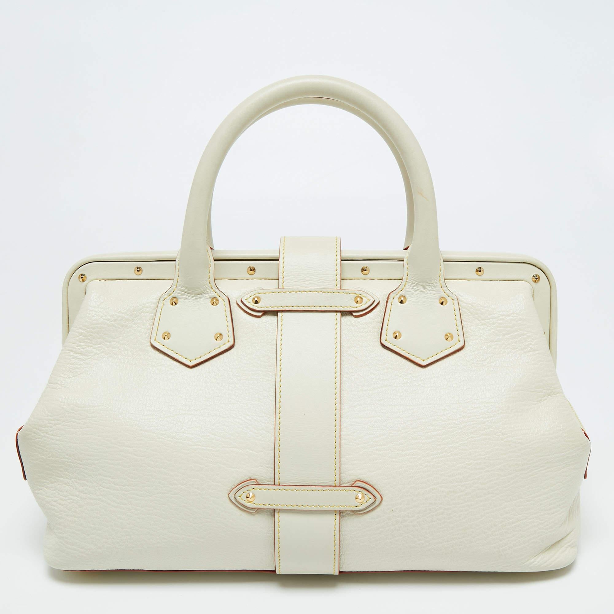 This Louis Vuitton Lingenieux PM bag is crafted to perfection. This off-white Suhali leather bag is adorned with gold-tone studs, a signature lock with the Louis Vuitton insignia, and side zip pockets. The interior is lined with fabric. The rolled
