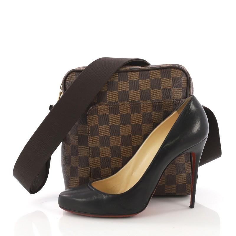 This Louis Vuitton Olav Handbag Damier PM, crafted from damier ebene coated canvas, features an adjustable textile strap, exterior flat pocket and gold-tone hardware. Its two-way zip closure opens to a brown fabric interior with slip pocket.