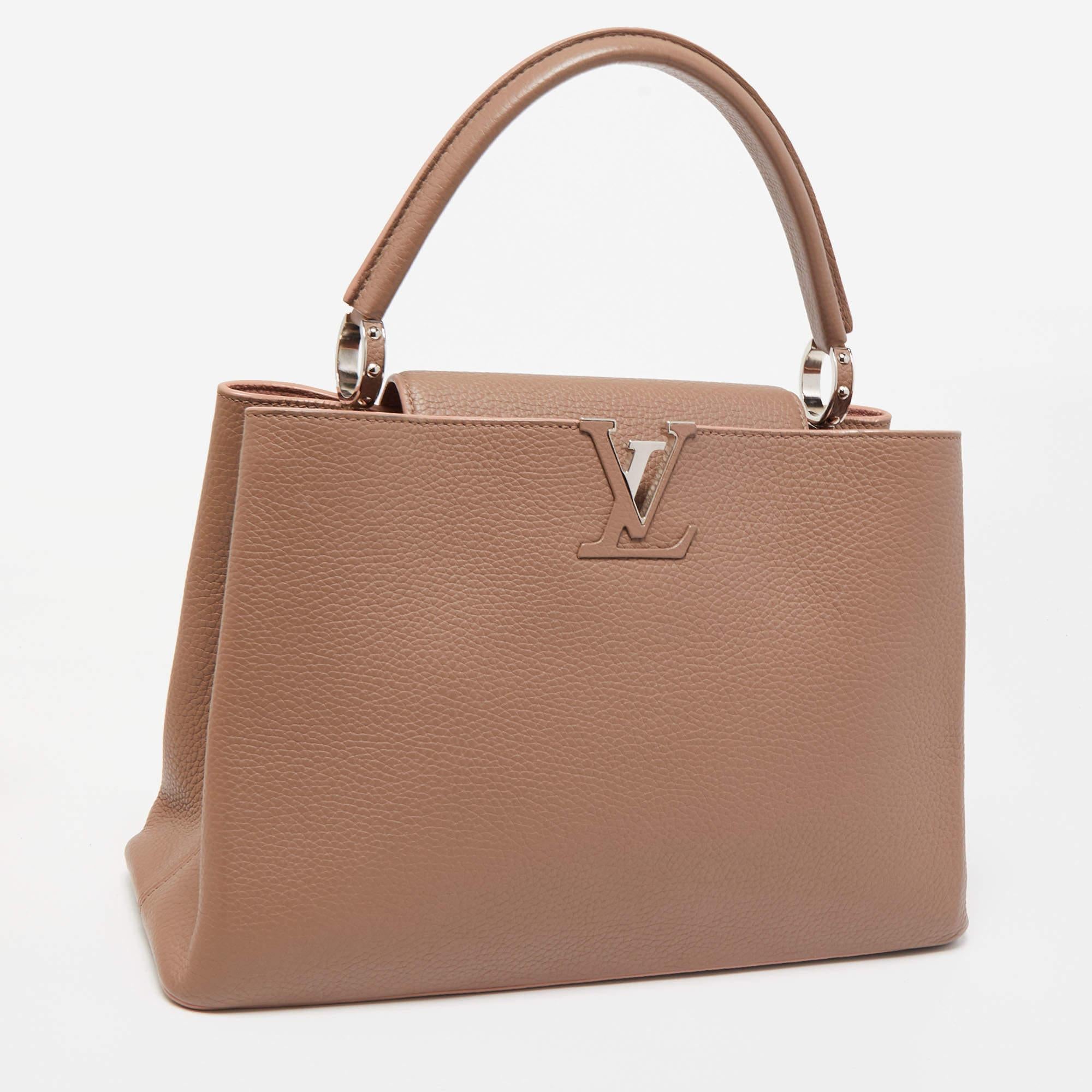 The Louis Vuitton Capucines bag is a luxurious fashion accessory known for its timeless elegance. Crafted from exquisite old rose-hued leather, it features a classic flap design with an LV logo-engraved metallic clasp. The interior is lined with