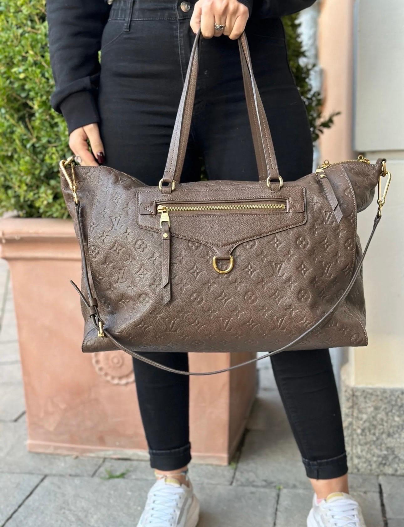Louis Vuitton signed bag, made of brown leather with classic Empreinte monogram logo and golden hardware.

Equipped with a double handle in leather and a removable and adjustable shoulder strap to wear the bag by hand and on the