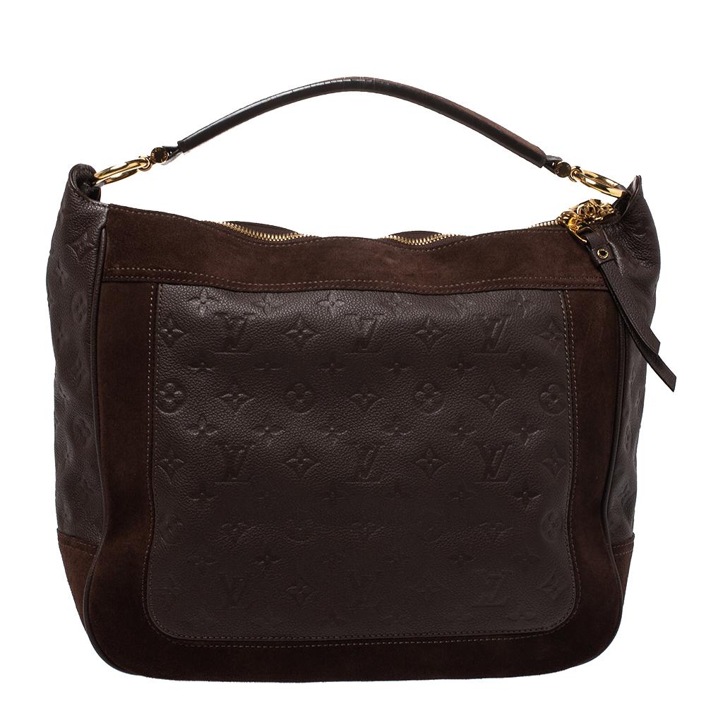 Flaunt this Louis Vuitton Audacieuse MM bag like a fashionista! Crafted from suede and monogram Empreinte leather, this bag was made in France and it features a top with double zippers that reveal a canvas-lined interior spacious enough to carry all