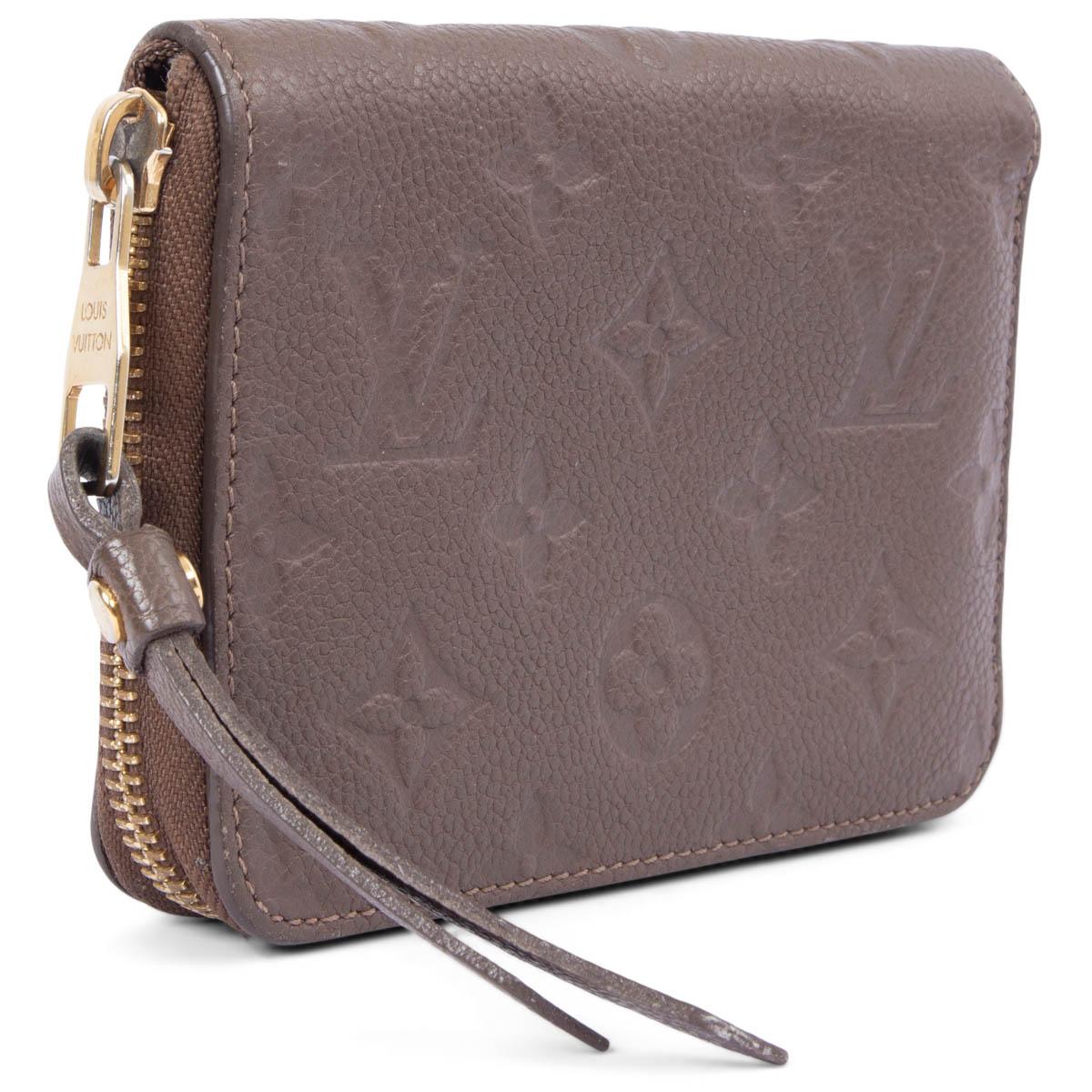 100% authentic Louis Vuitton Secret Compact Wallet in Ombre taupe Monogram Empreinte grained calfskin featuring gold-tone hardware. Opens with a zipper on top and is lined in red calfskin with three credit card slots, a zipped coin-pocket and a