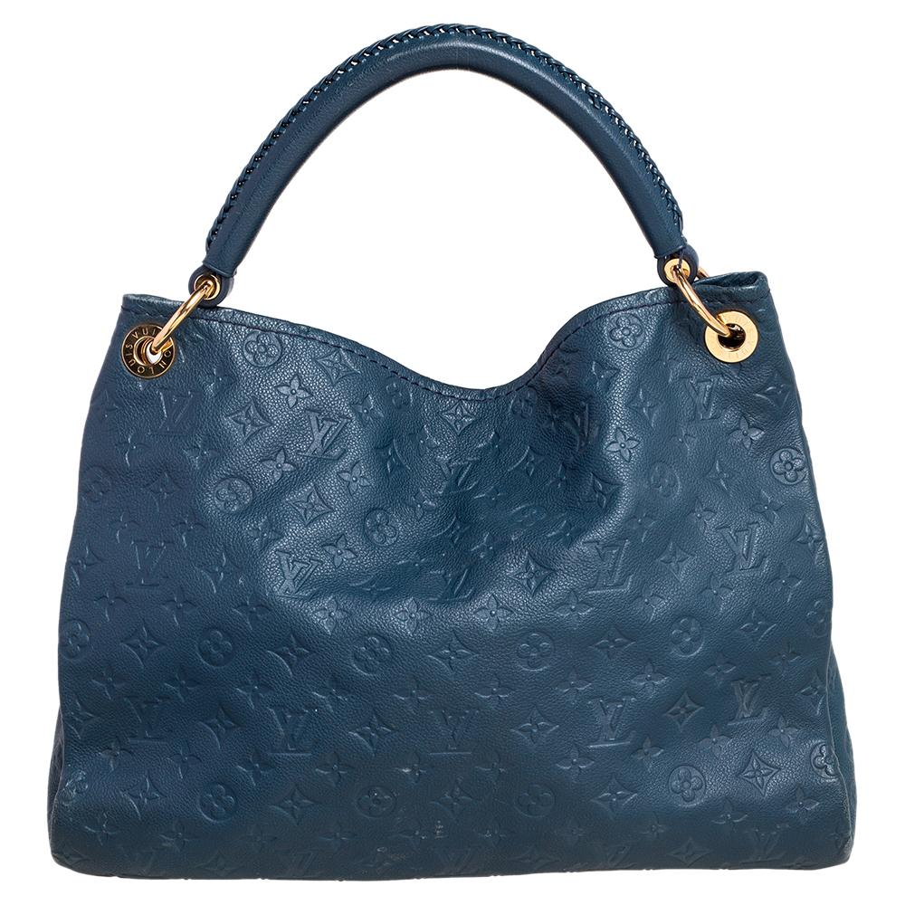 Flaunt this Louis Vuitton Artsy bag like a fashionista! Crafted from their signature Empreinte leather, this bag features an open top that reveals a canvas-lined interior, spacious enough to carry all your essentials. The bag is completed with a