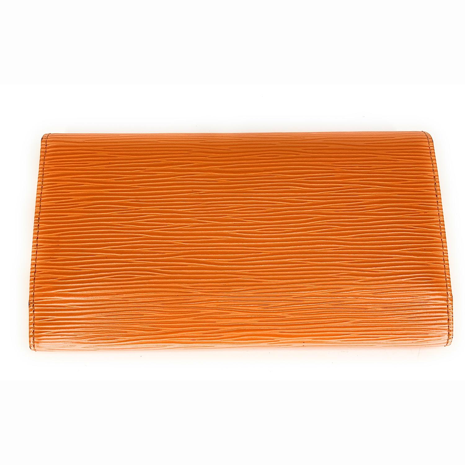 This is a gorgeous wallet from Louis Vuitton. Crafted from orange Louis Vuitton Epi leather, this wallet is both practical and fashionable. Its interior, secured with a stud closure, has six credit card slots, two open slip pockets for banknotes,