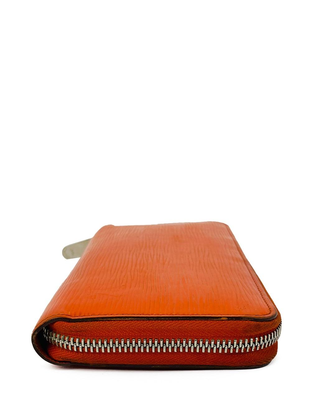 Brighten up your accessories collection with this bold Louis Vuitton orange Epi leather zip-around wallet. Crafted from the house’s iconic textured Epi leather, this wallet is both durable and stylish. The vibrant orange hue adds a playful pop of