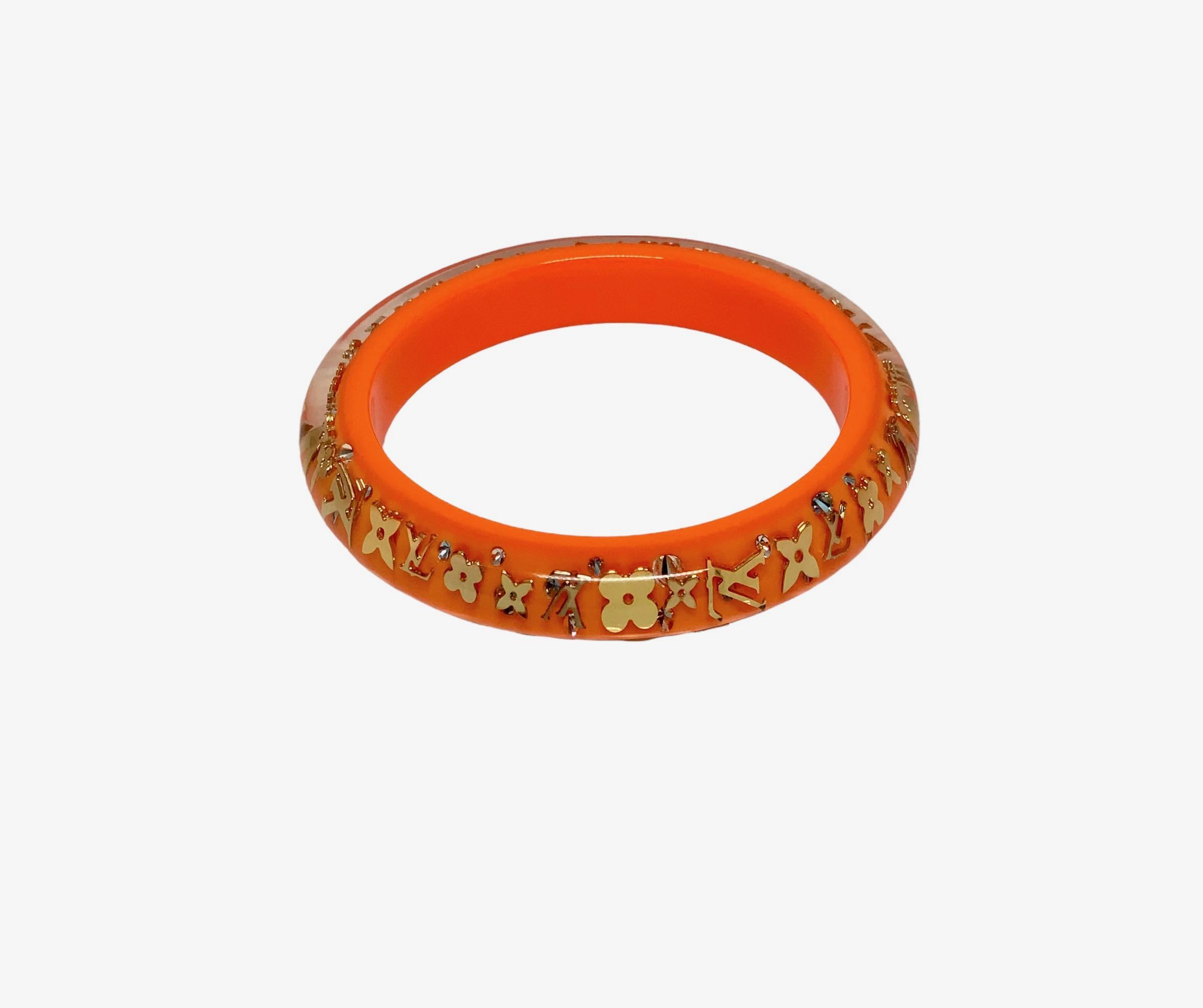 Very nice pre-owned bangle form the Inclusion Monogram collection from Louis Vuitton.
Crafted in a clear resin with orange, gold-tone LV monogram inclusion and rhinestones.

Collection: Inclusion Monogram
Color: Orange and goldtone 
Materials: