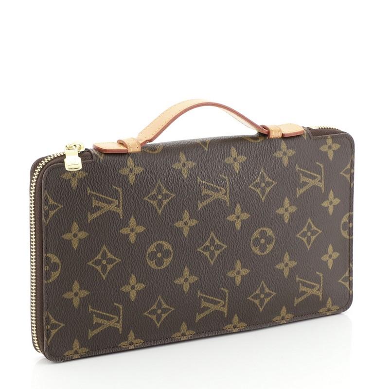 This Louis Vuitton Organizer de Voyage Monogram Canvas, crafted from brown monogram coated canvas, features gold-tone hardware. Its zip around closure opens to a brown leather interior with middle zip compartment, multiple card slots, and slip