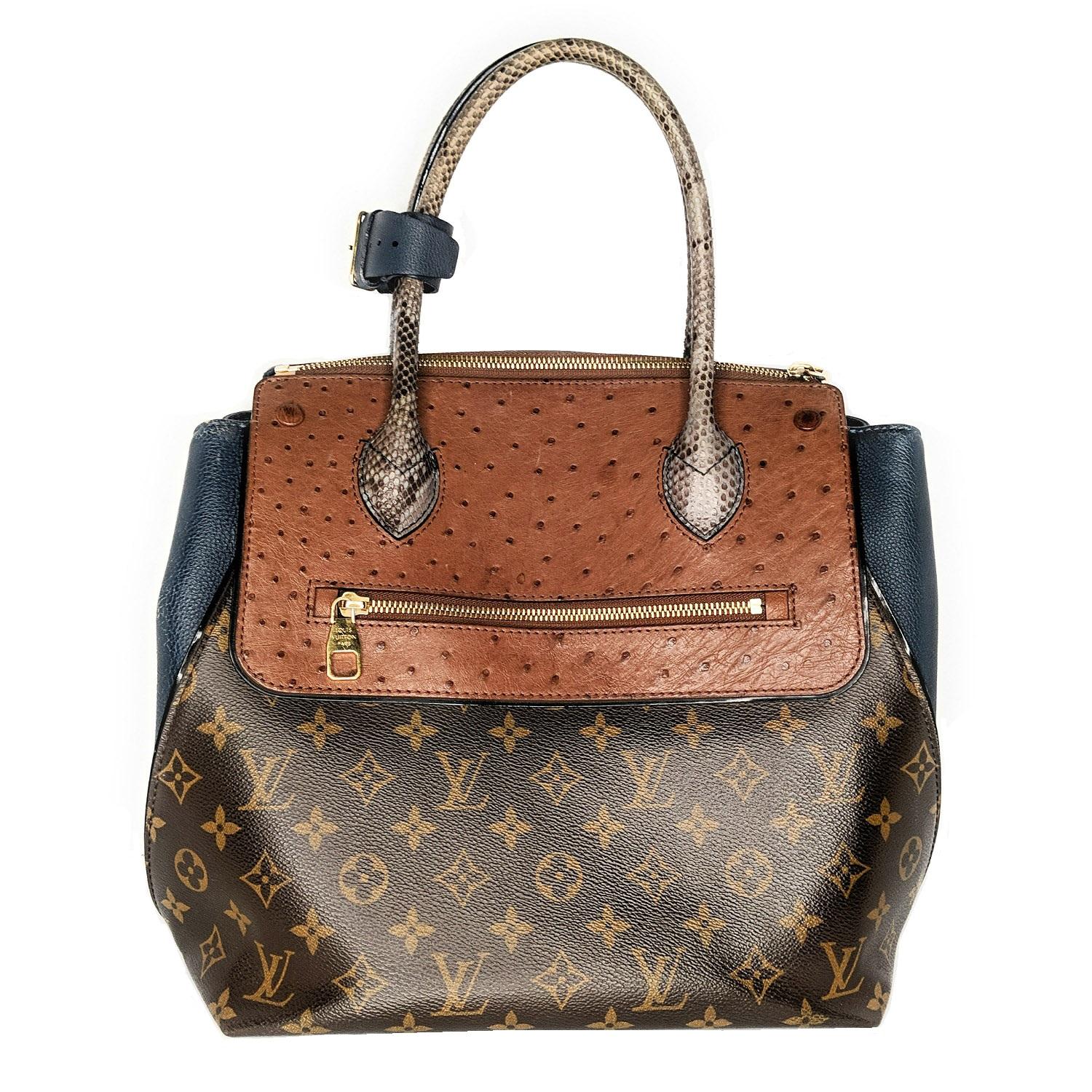 This stylish tote has a body of Louis Vuitton monogram on toile canvas. The bag features rolled python top handles with expandable full grain blue calfskin leather sides. There is a rear backing and zipper pocket and a cross-over flap of ostrich
