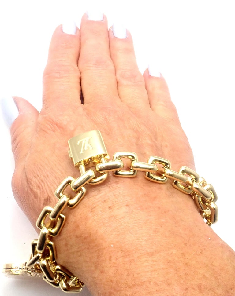 LOT:493  LOUIS VUITTON - an 18ct gold charm bracelet with padlock