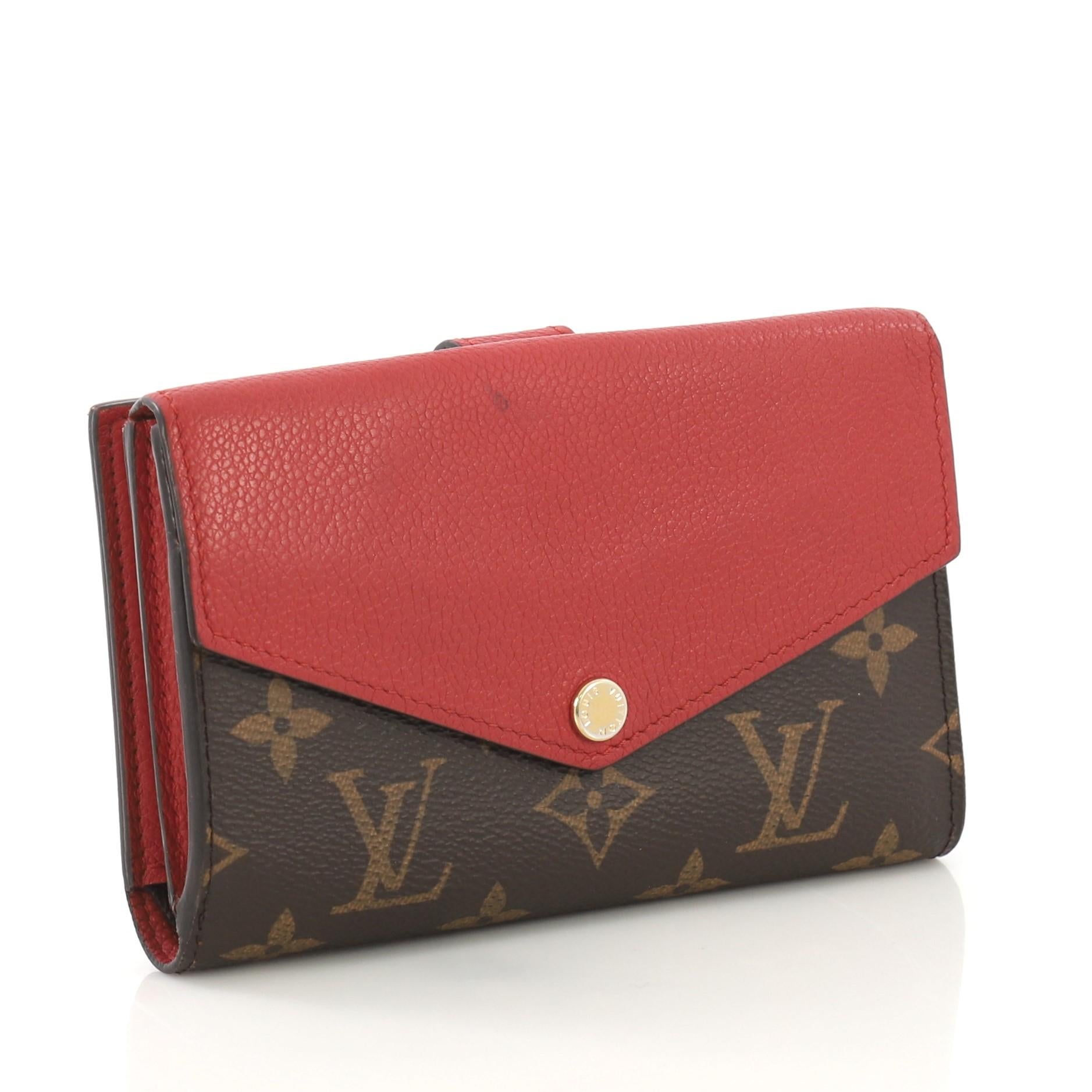 This Louis Vuitton Pallas Compact Wallet Monogram Canvas and Calf Leather, crafted from brown monogram coated canvas and red calf leather, features envelope flap opening, gusseted compartment, and gold-tone hardware. It opens to a red leather